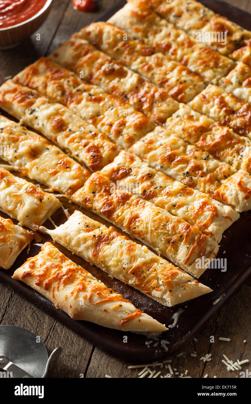 Homemade Cheesy Breadsticks with Marinara Sauce for Dipping Stock Photo