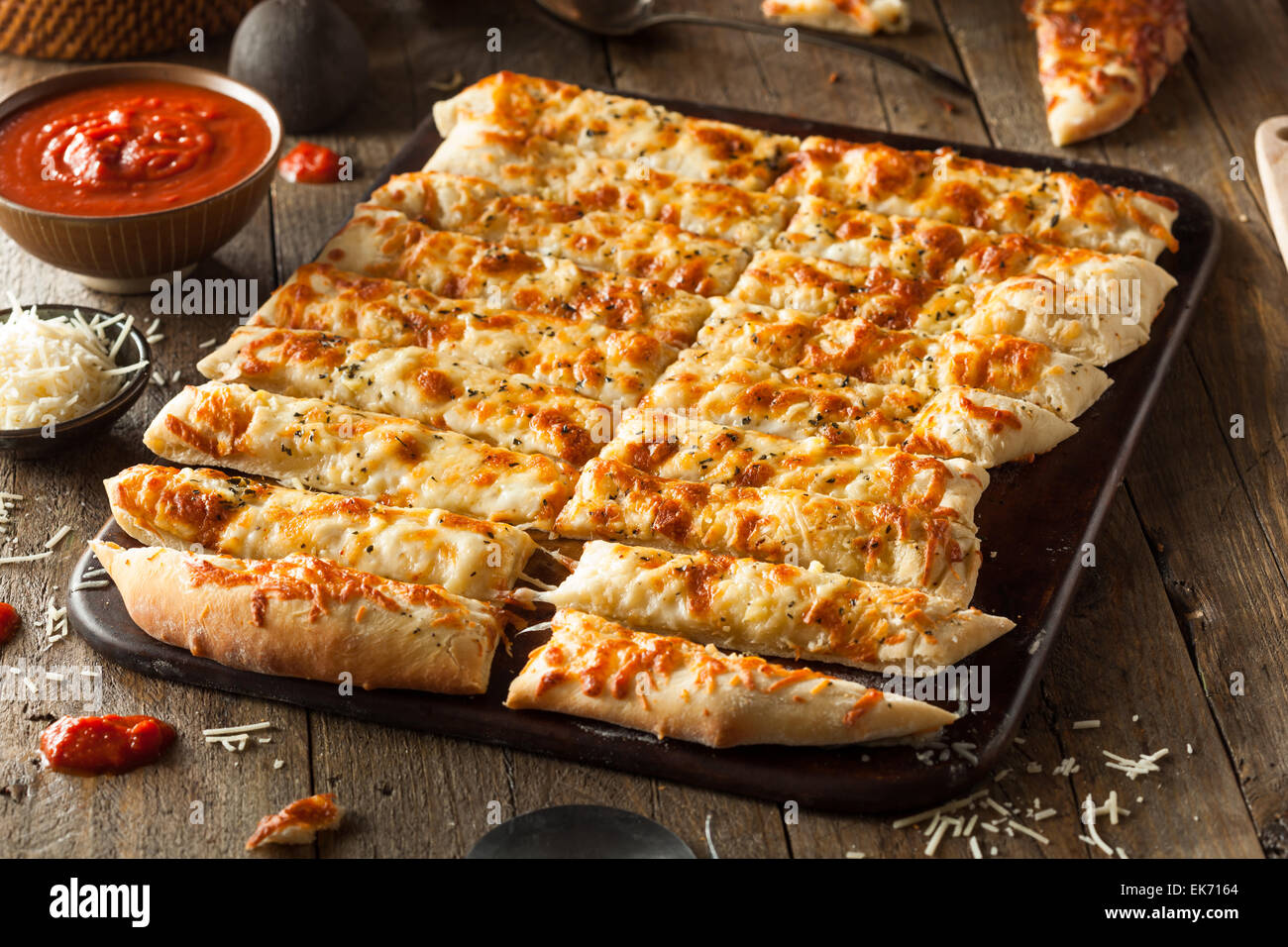 Homemade Cheesy Breadsticks with Marinara Sauce for Dipping Stock Photo