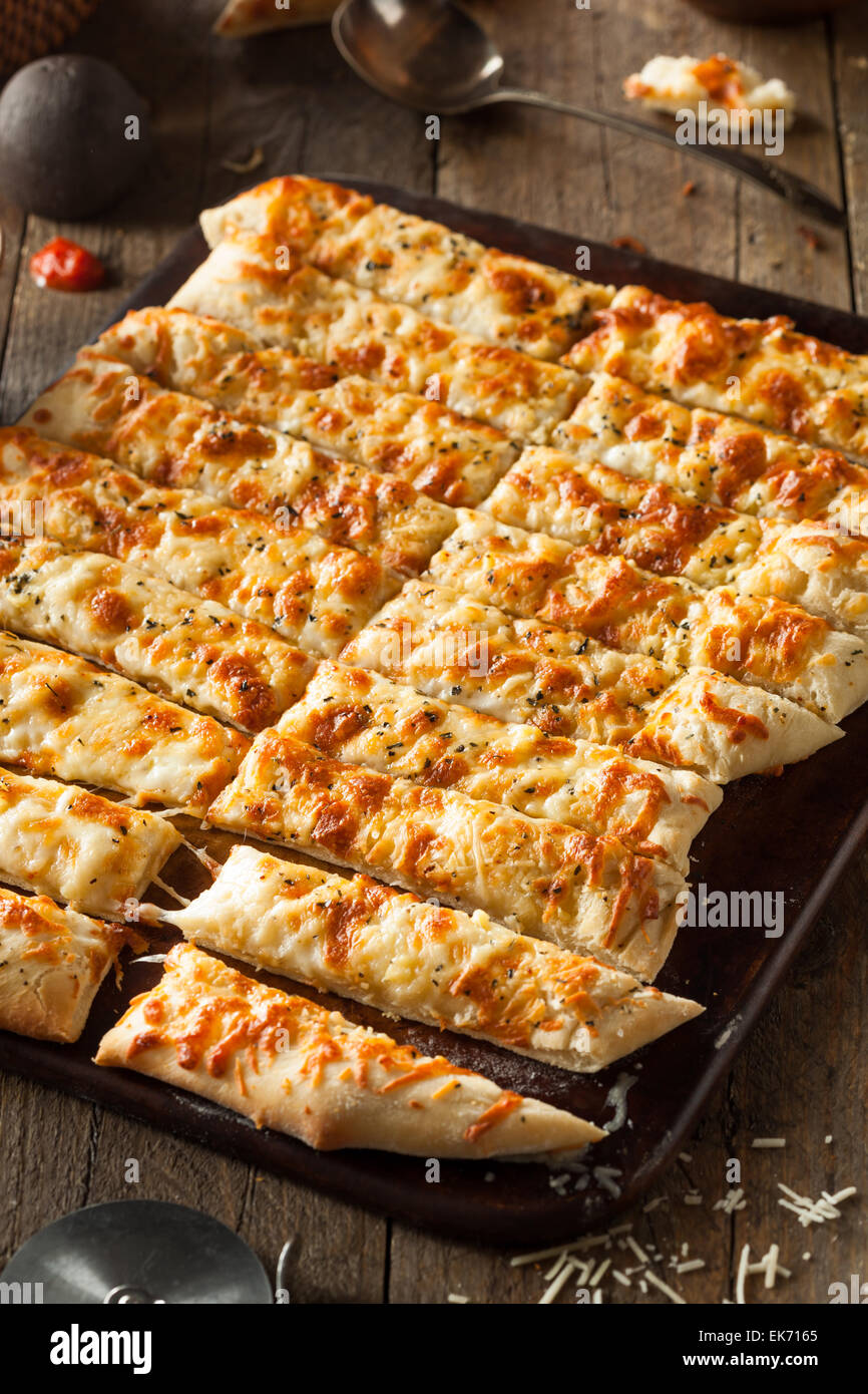Homemade Cheesy Breadsticks with Marinara Sauce for Dipping Stock Photo