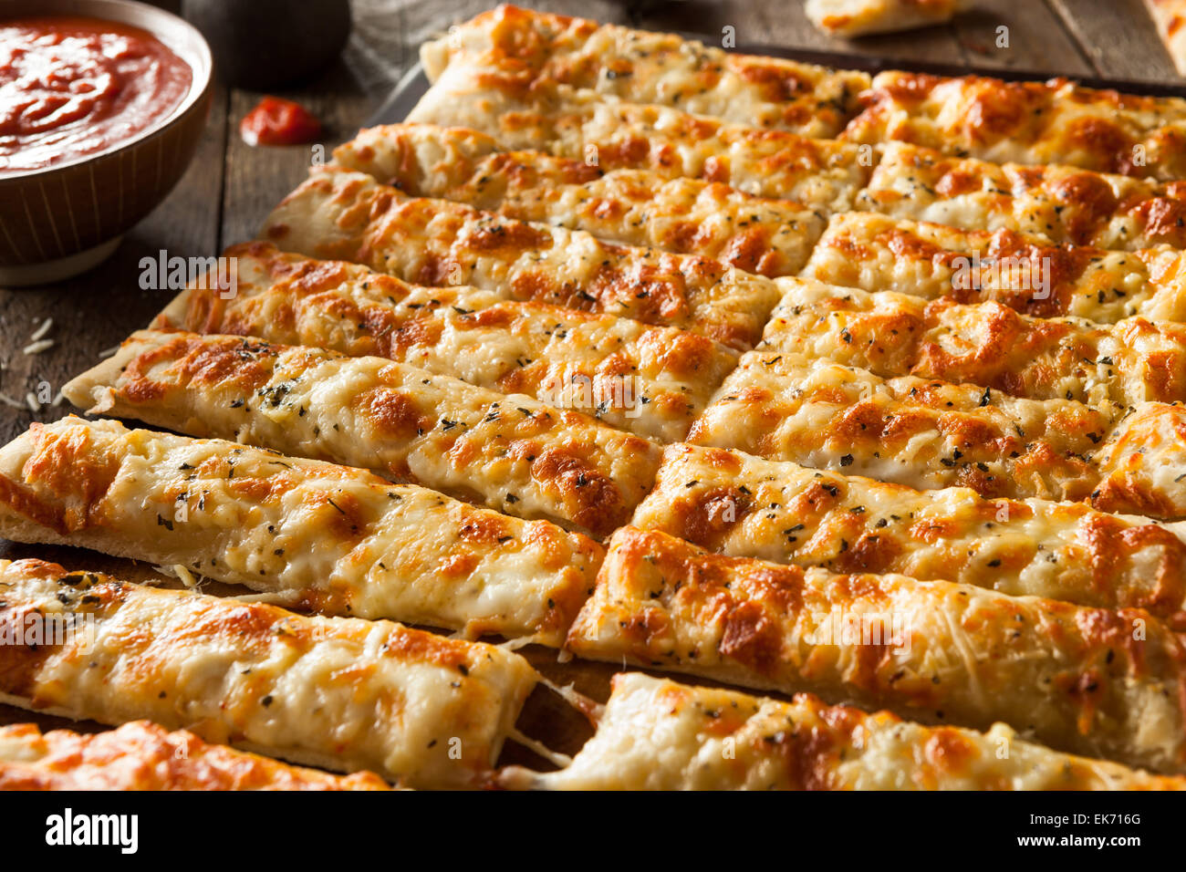 Homemade Cheesy Breadsticks with Marinara Sauce for Dipping Stock Photo