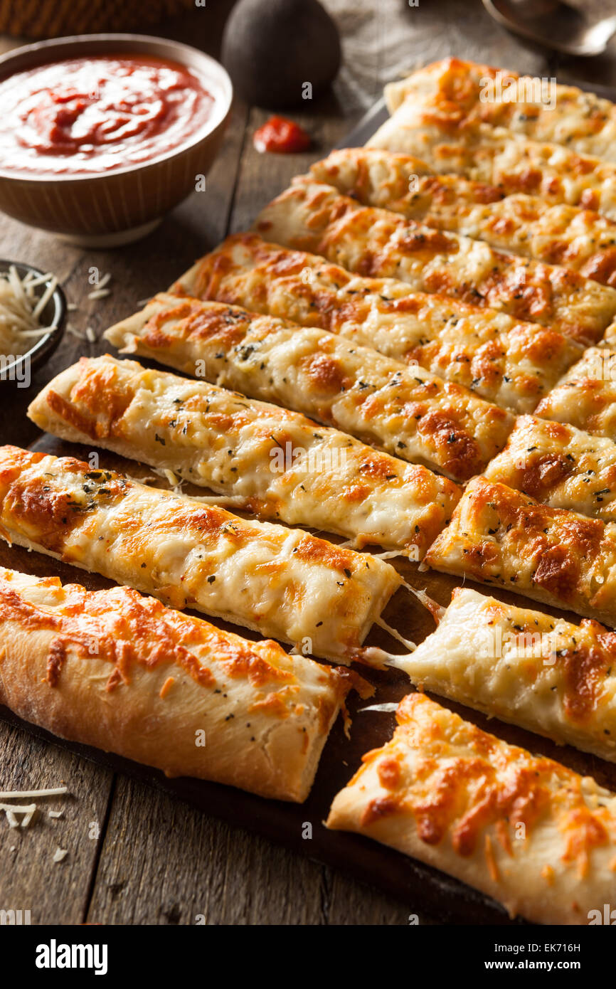 Homemade Cheesy Breadsticks with Marinara Sauce for Dipping Stock Photo