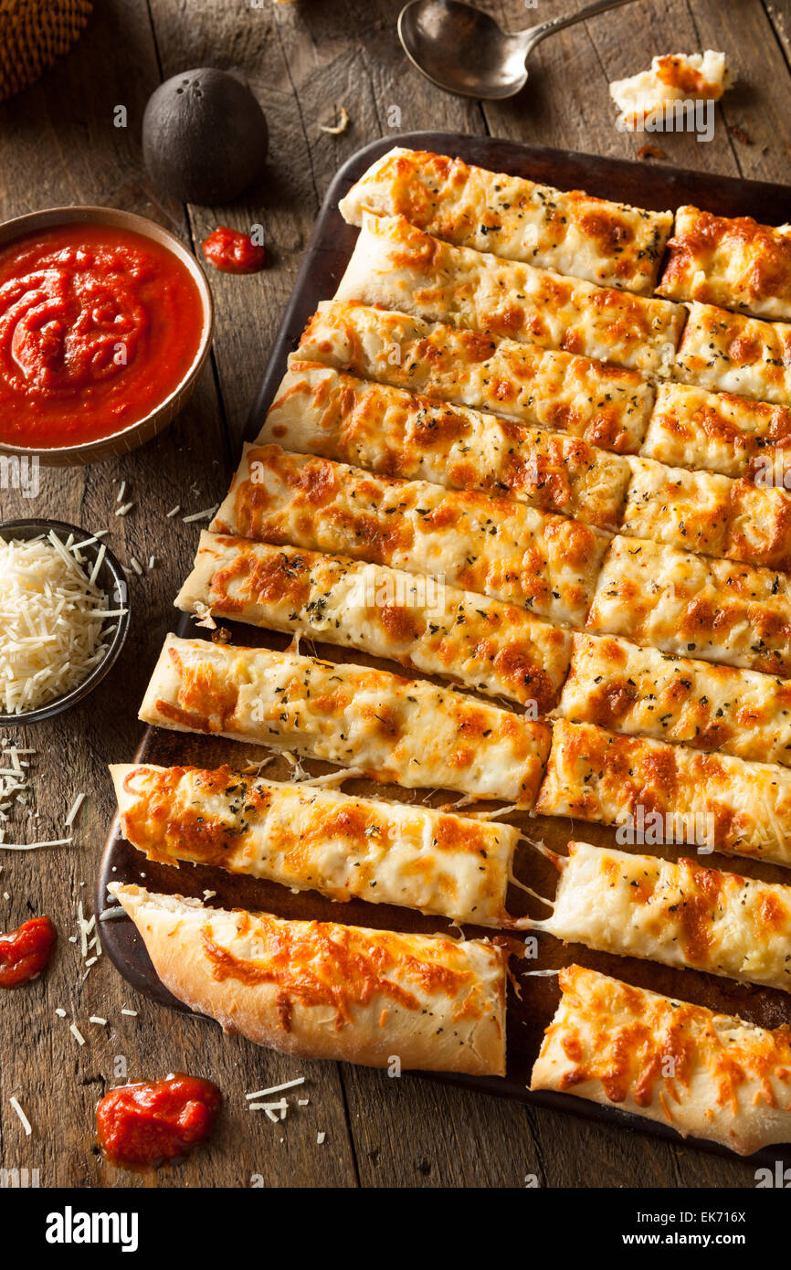 Homemade Cheesy Breadsticks with Marinara Sauce for Dipping Stock Photo
