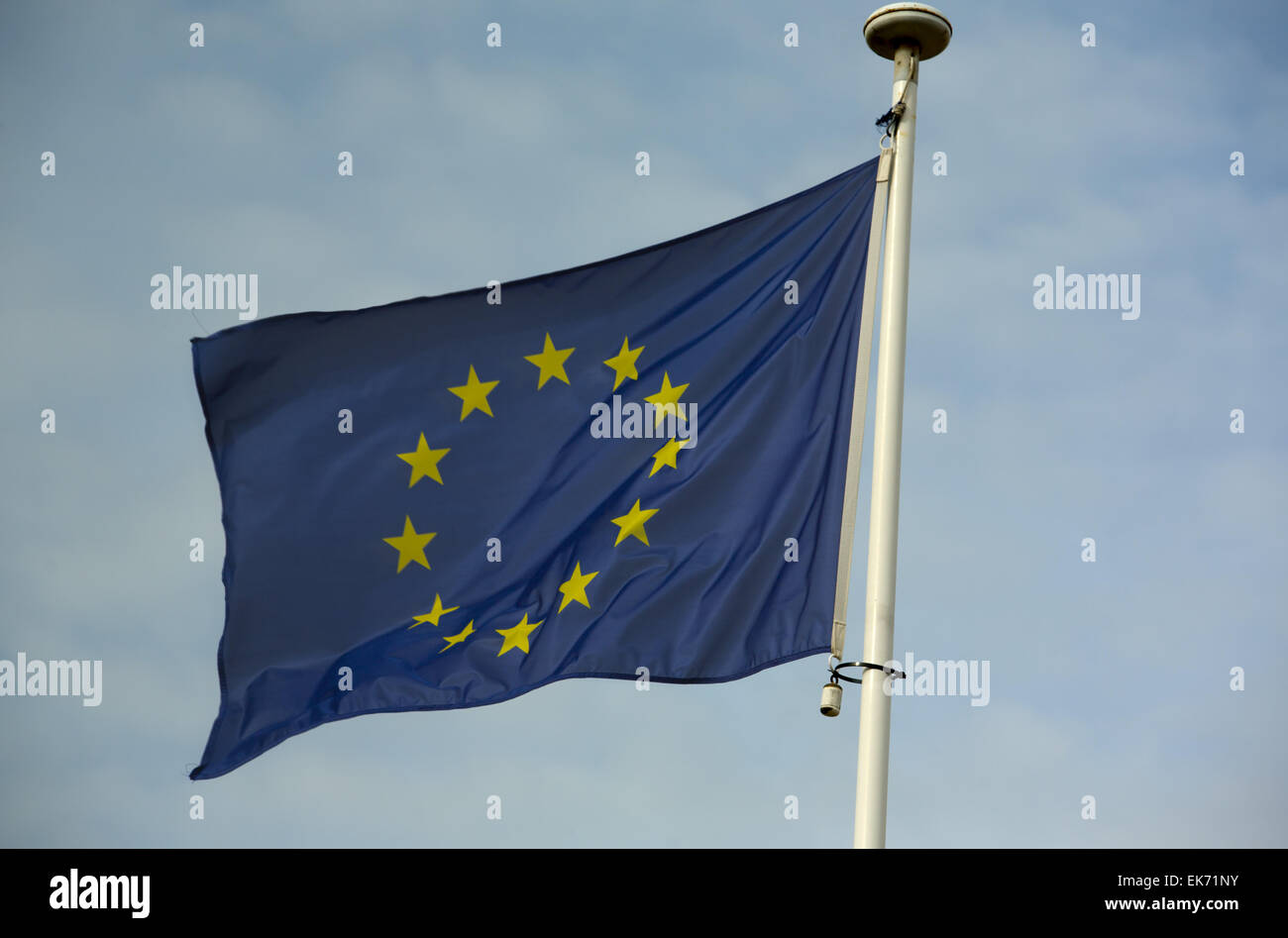 European Union flag fluttering in a brisk breeze against a cloudy sky Stock Photo