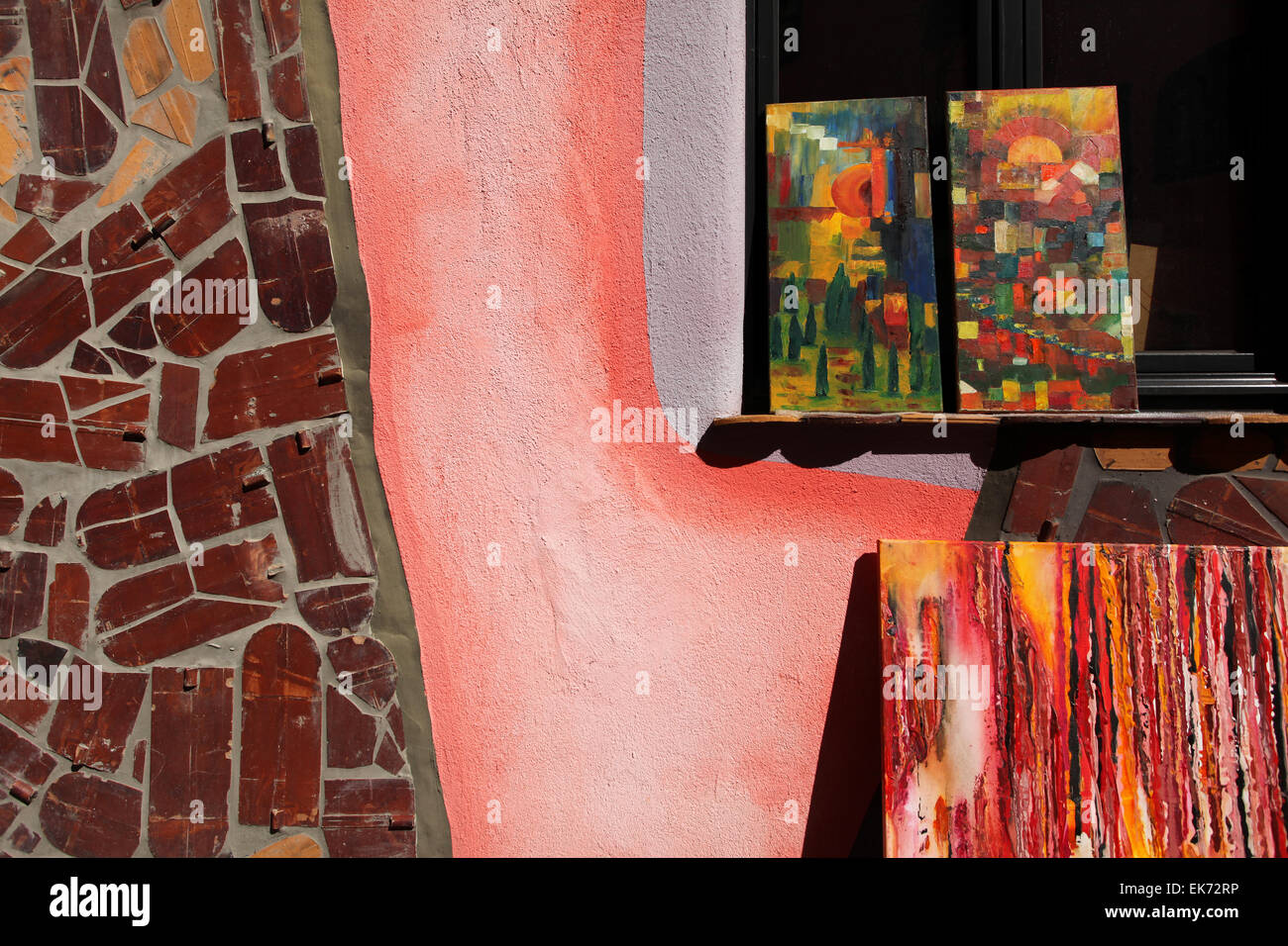 Exhibited paintings of a shop in the Green Citadel, designed by the architect Friedensreich Hundertwasser. Magdeburg, Germany. Stock Photo