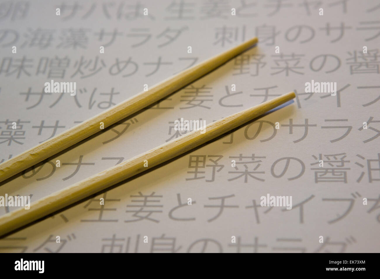 Two brown wooden chopsticks on bamboo cover over Paper Table Mat of a  restaurant with japanesse writting Stock Photo - Alamy