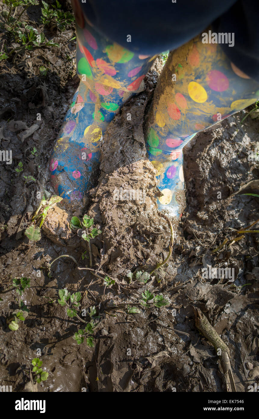 Pair of children's colorful wellington boots treading squelchy muddy ...