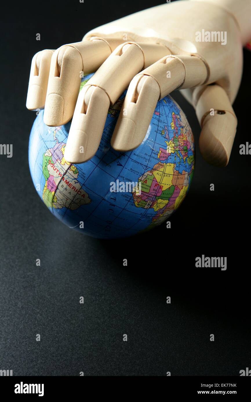 The world map in wood mannequin hand, black backgorund Stock Photo Alamy