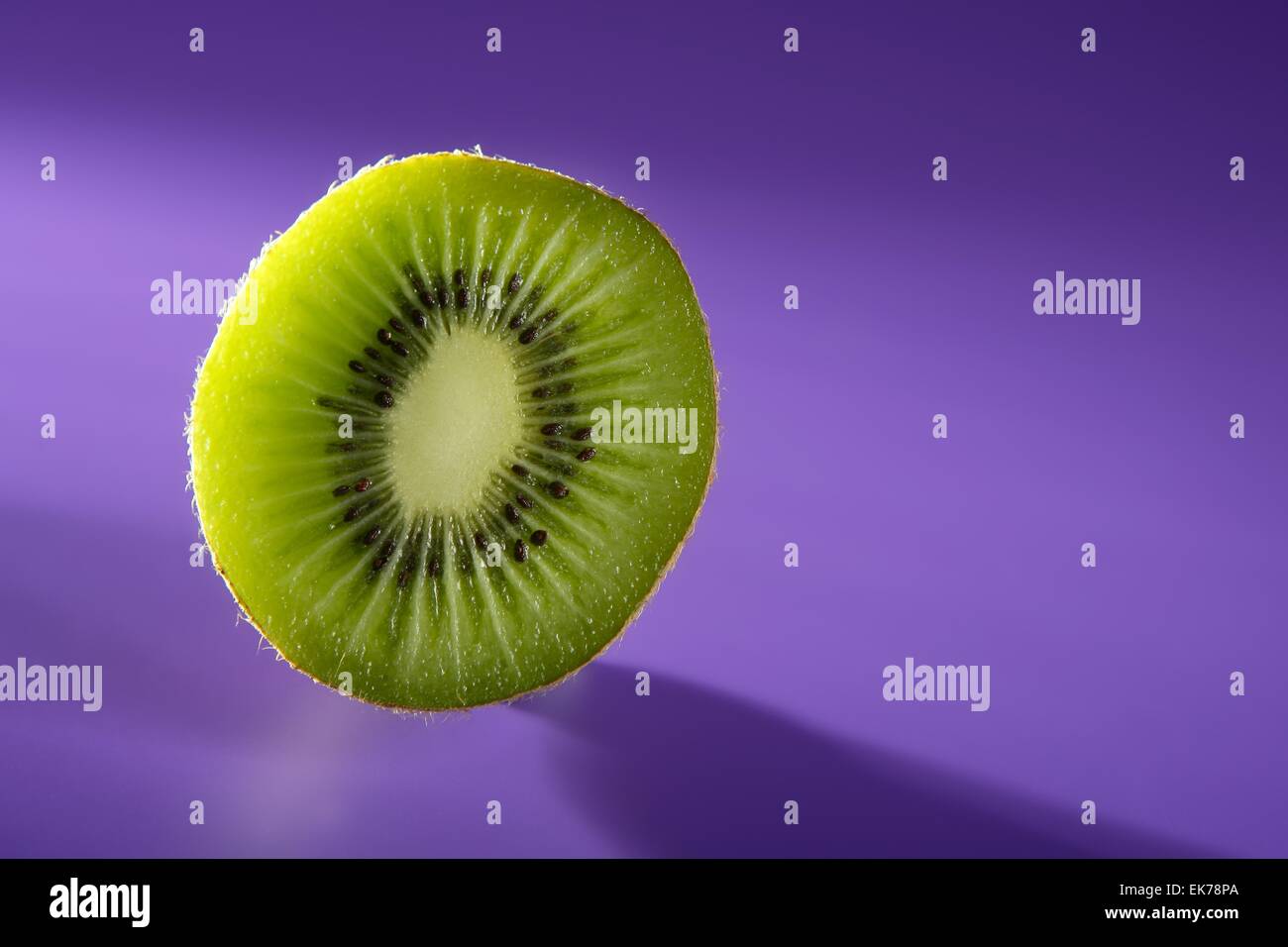 Green Kiwi slice over vivid purple background Stock Photo - Alamy