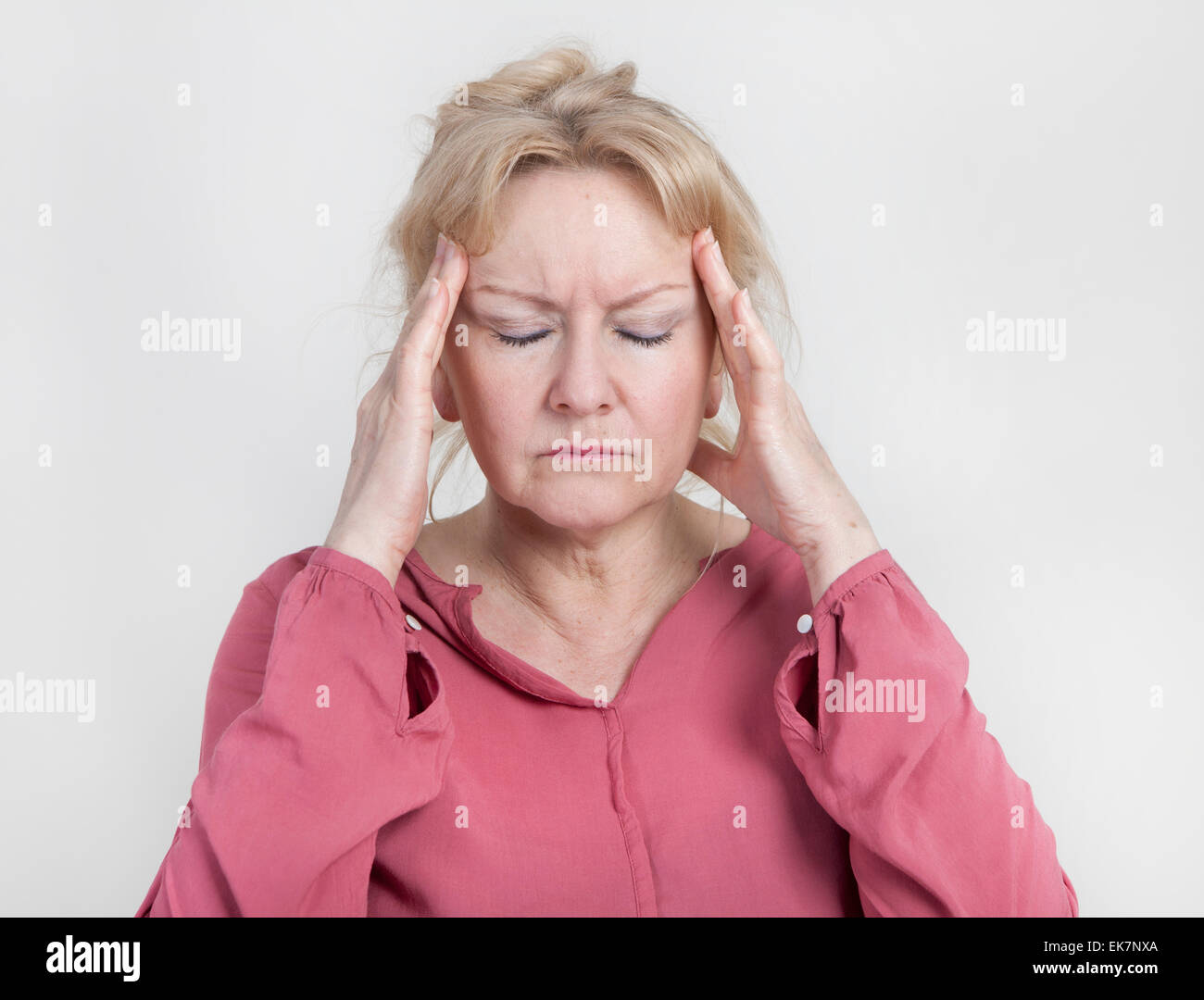 an older woman has pain and holds his head Stock Photo
