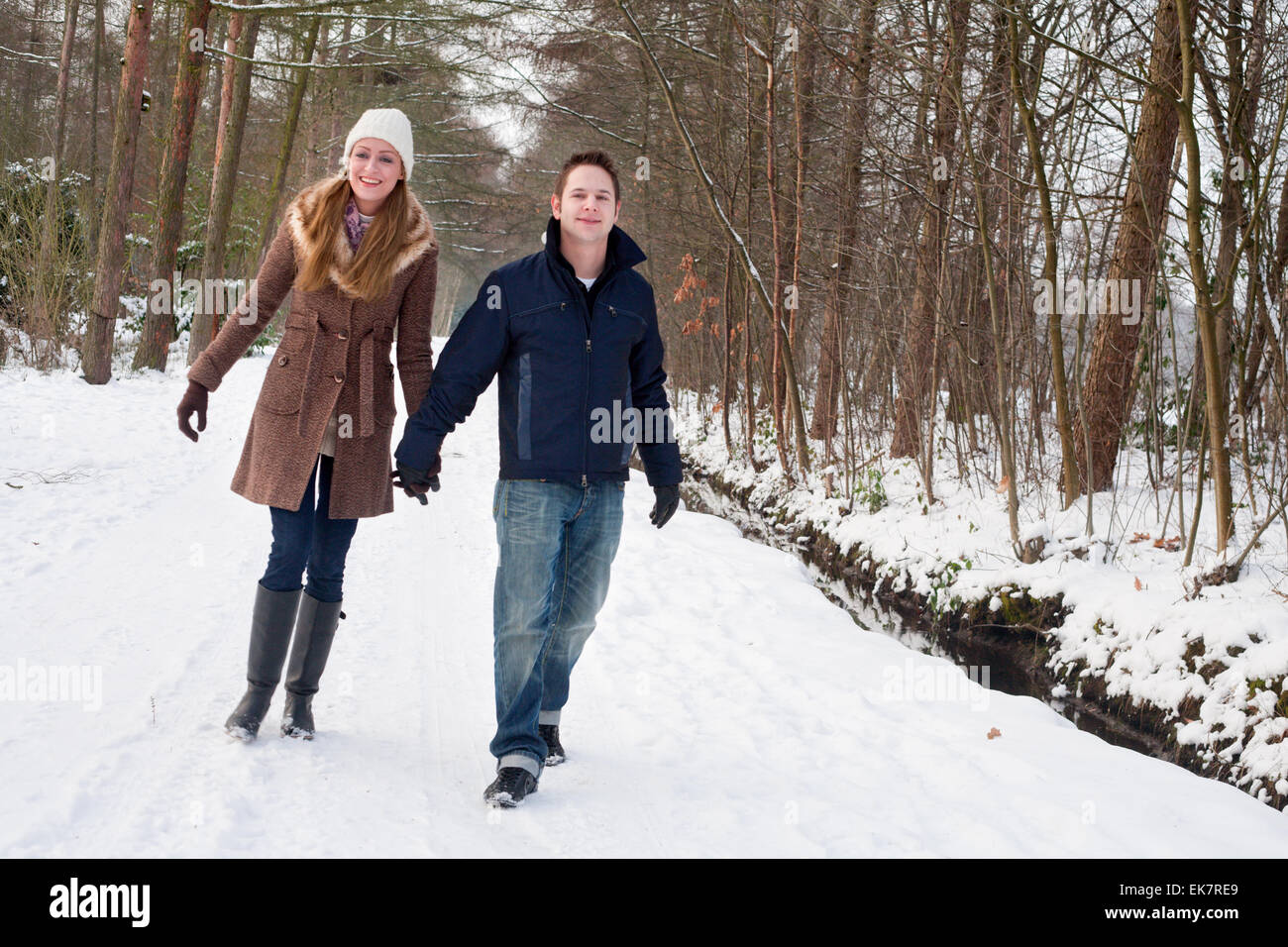 Young couple have a forest winter walk Stock Photo - Alamy