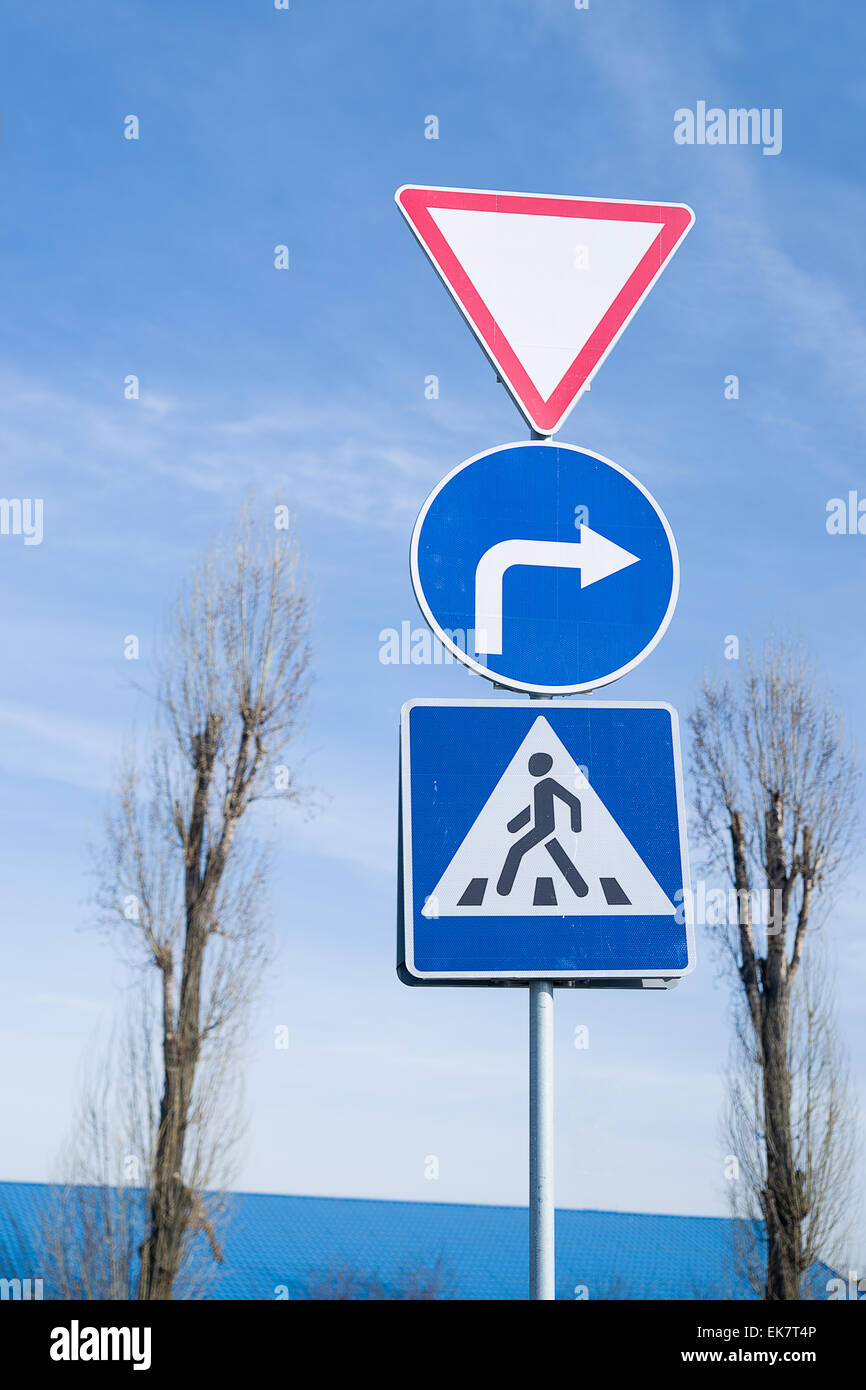 Various road signs on a pole against the blue sky Stock Photo