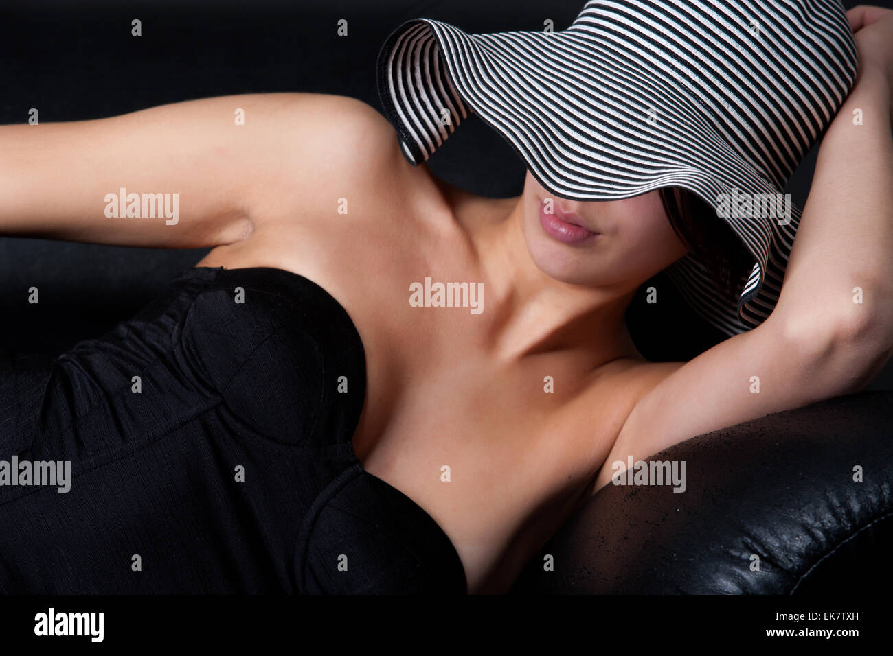 Young mult etnic woman in 50's lingery on couch Stock Photo