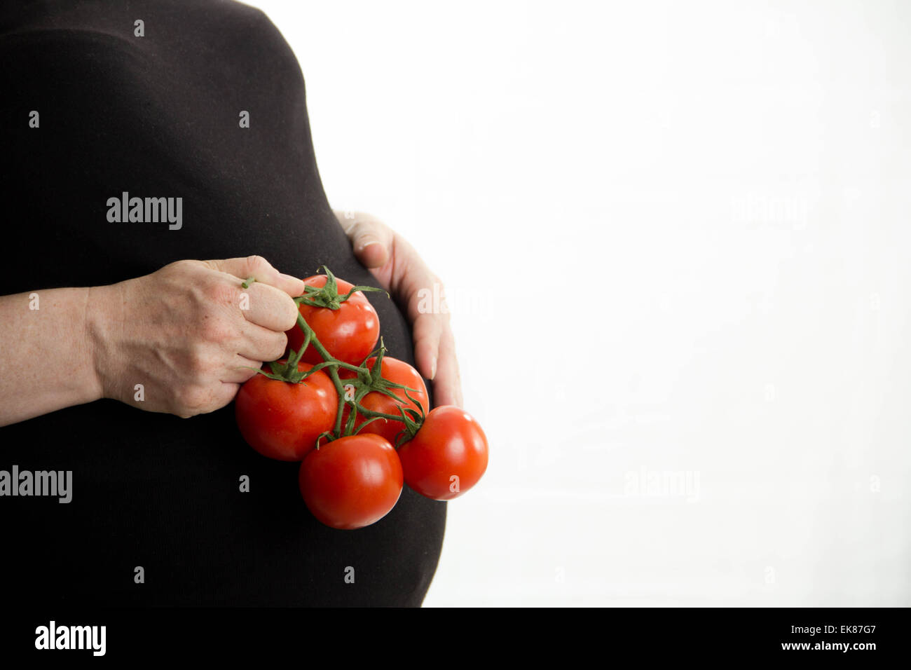 pregnant girl holding tomatoes in her hand, healthy food isolated on