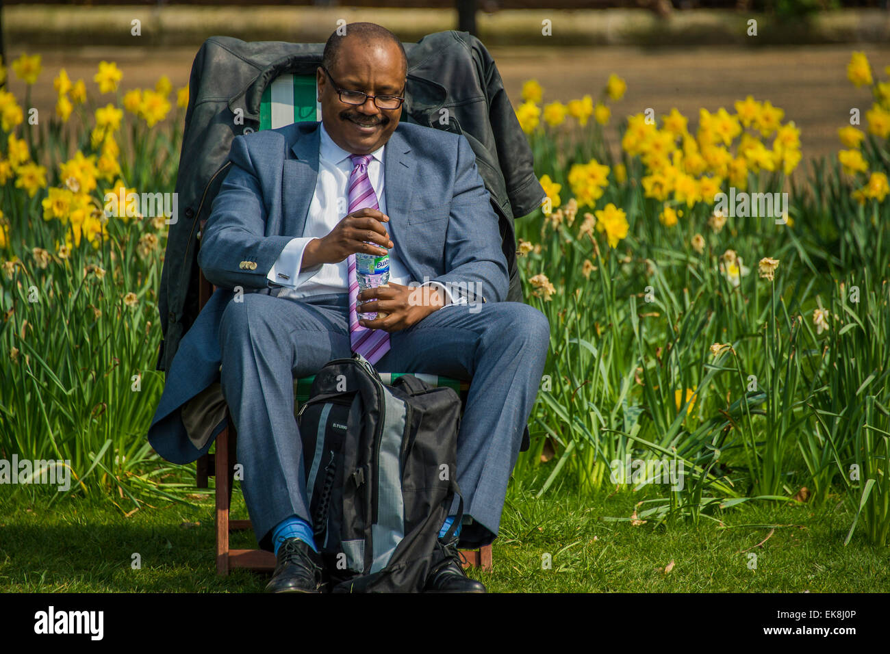 London, UK. 08th Apr, 2015. An office worker is happy with his luch in front of a sea of daffodils. The spring sun  brings out workers and tourists at lunchtime. They enjoy relaxing in the deckchairs or even using them as outdoor offices. Green Park, London, 08 Apr 2015. Credit:  Guy Bell/Alamy Live News Stock Photo