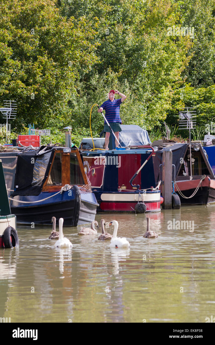 Man cleaning narrowboat narrow boat moored on the and Avon Canal