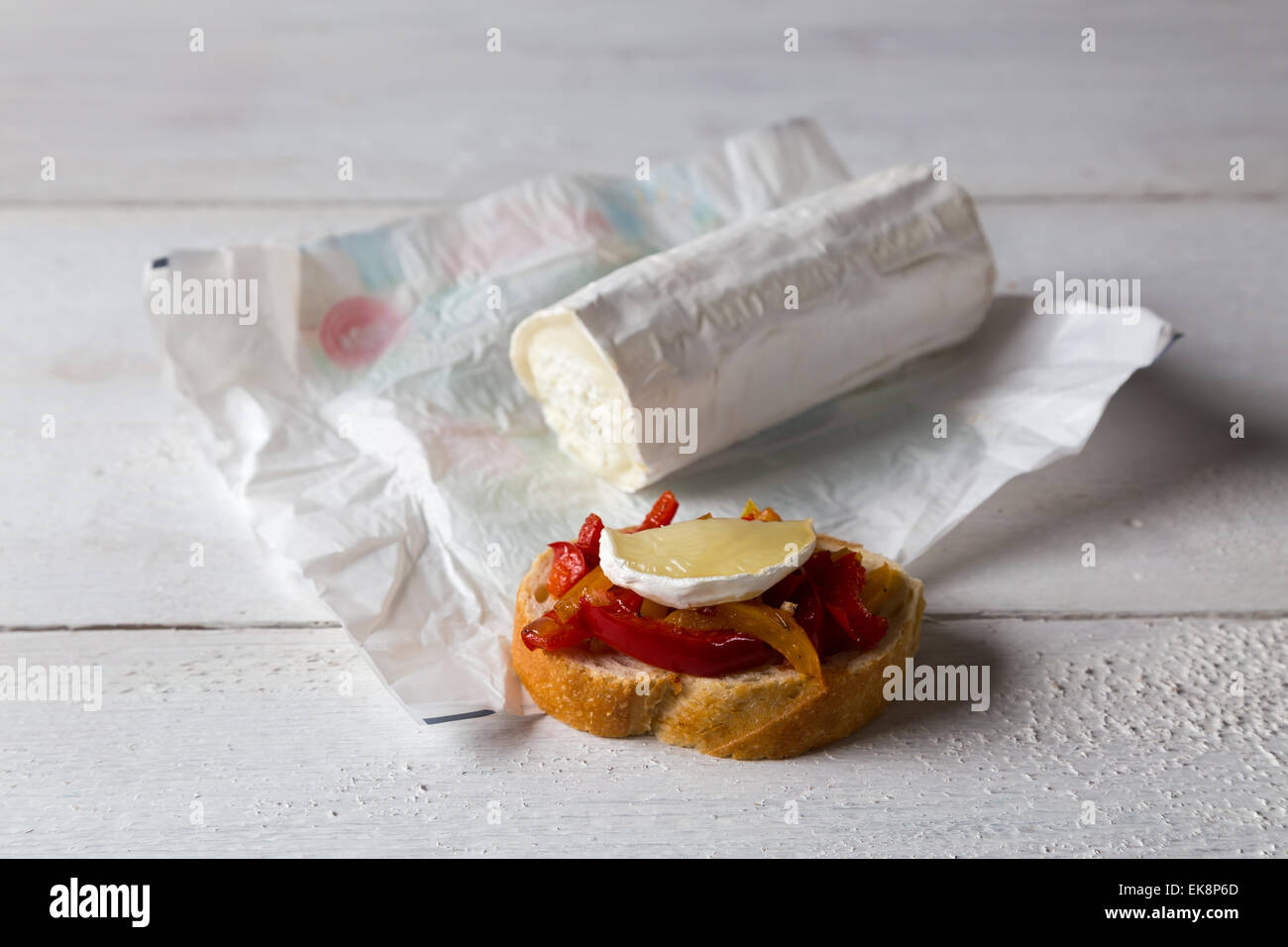 Bruschetta with peppers and goat cheese on a wooden board Stock Photo