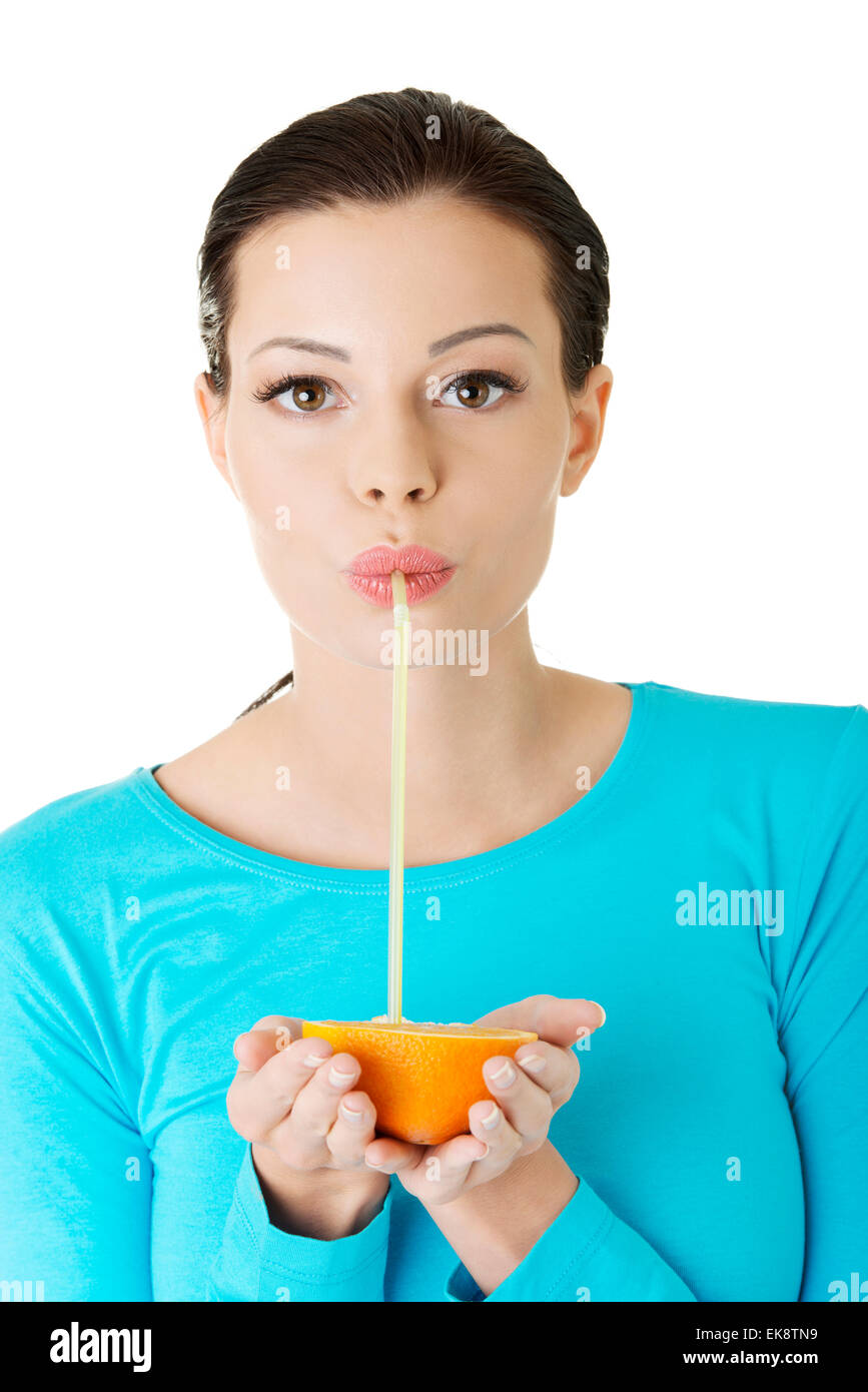 Woman drinking orange juice straight from fruit Stock Photo Alamy