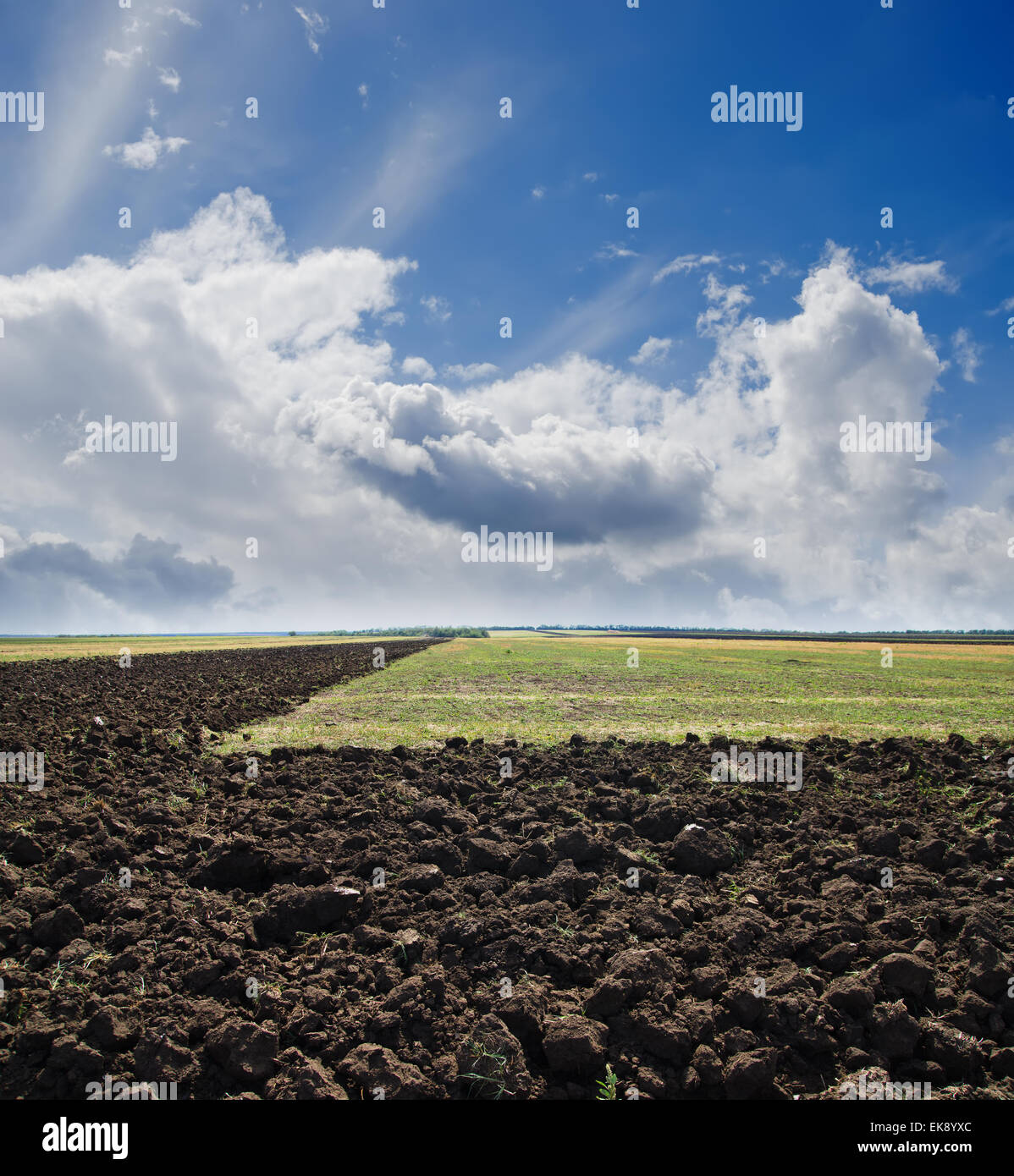 black ploughed field under cloudy sky Stock Photo - Alamy