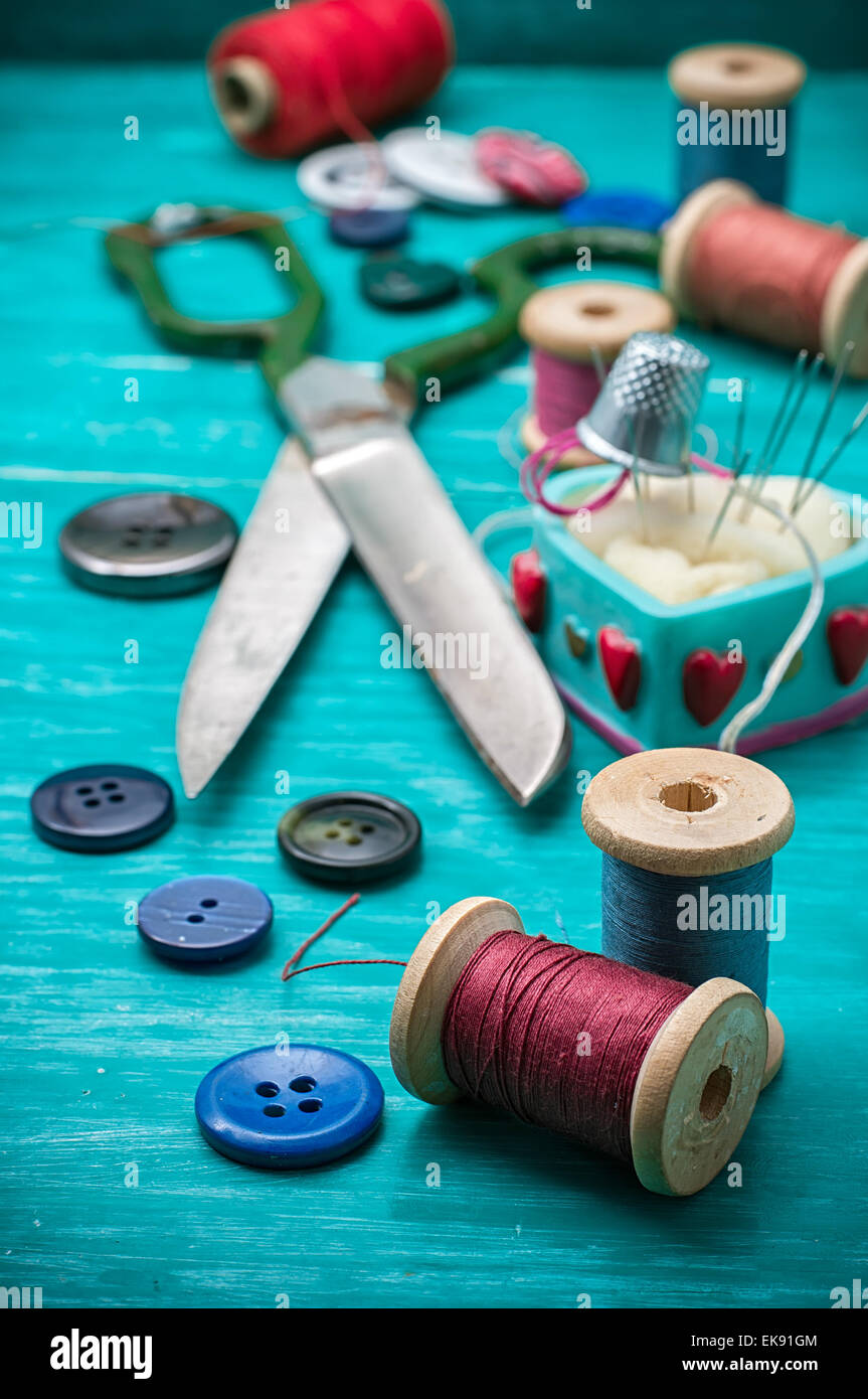 thread buttons for crafts on turquoise wooden background.Selective