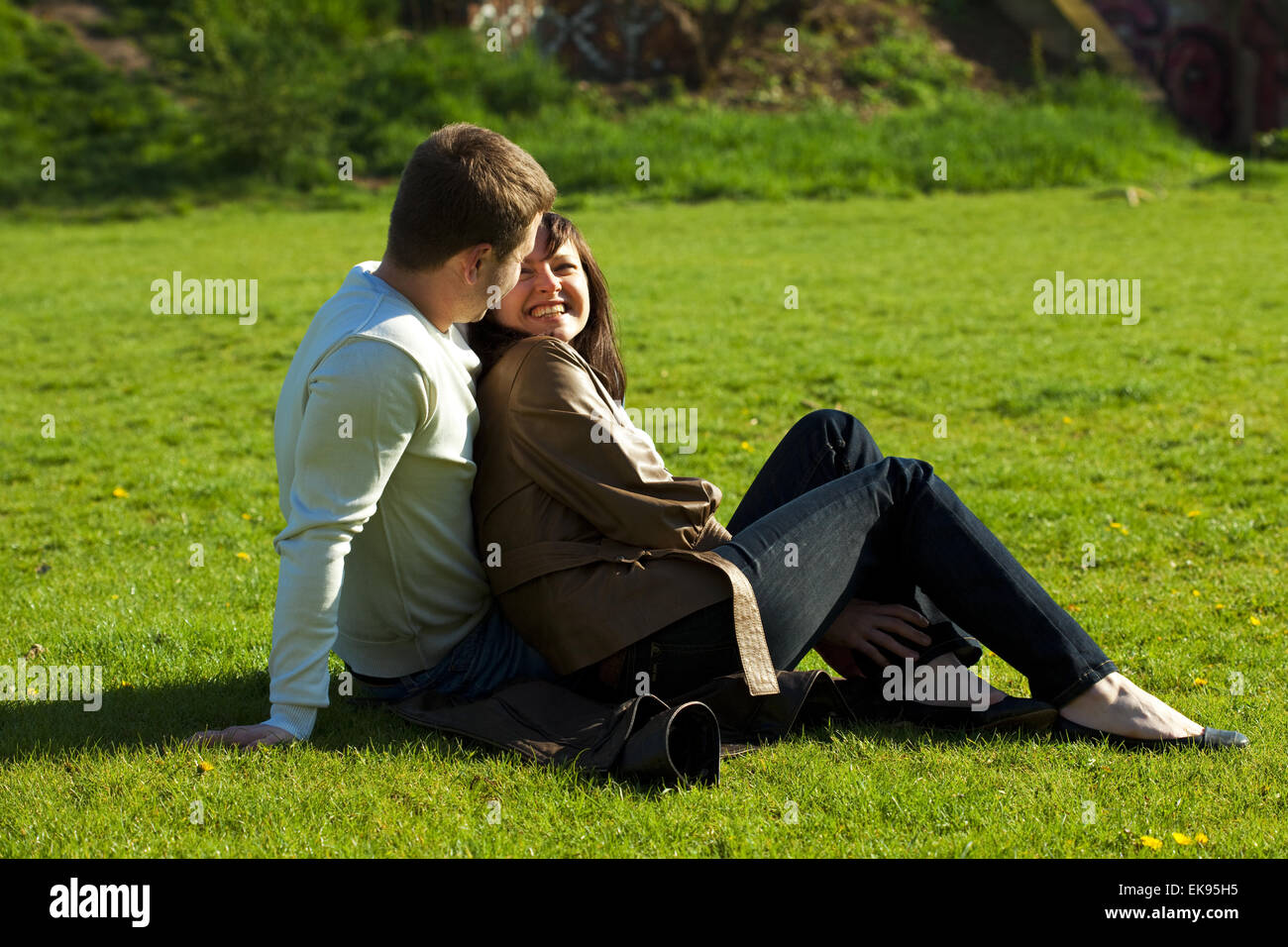 young couple sitting on the green grass Stock Photo - Alamy