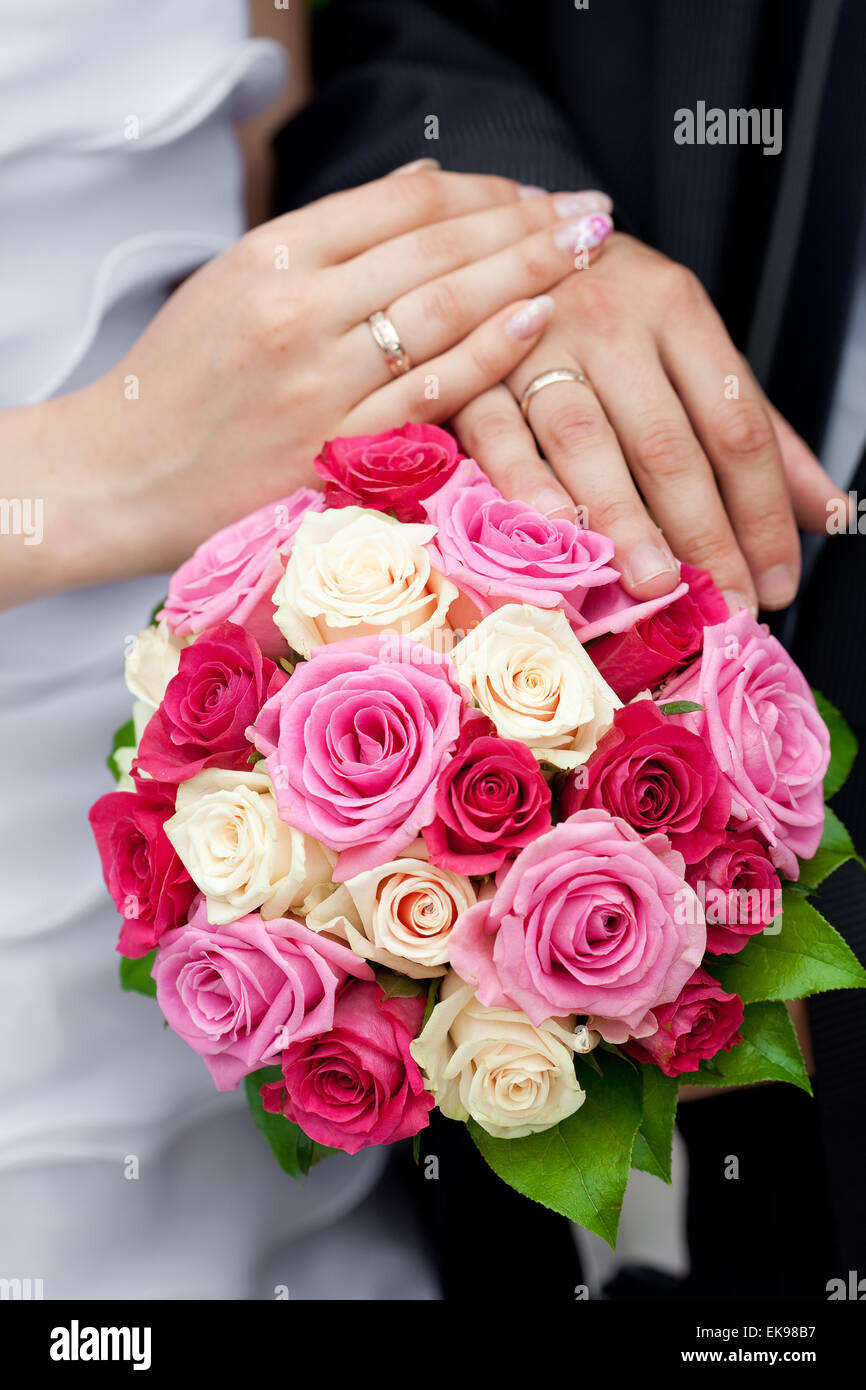 the hands of the bride and groom lying on the bridal bouquet Stock ...