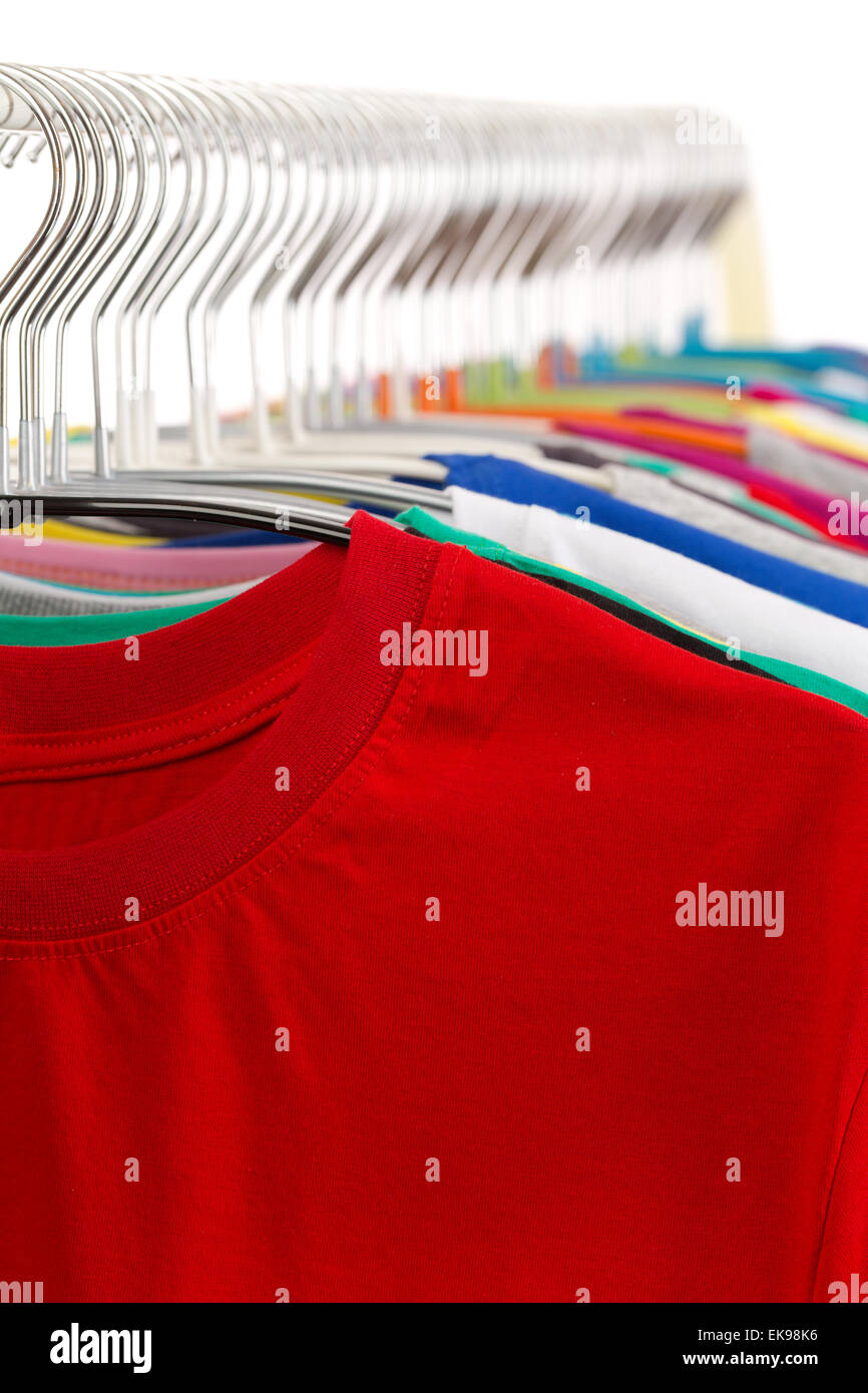 Colorful t-shirts on a flea market clothing rack. Isolate on white. Stock Photo