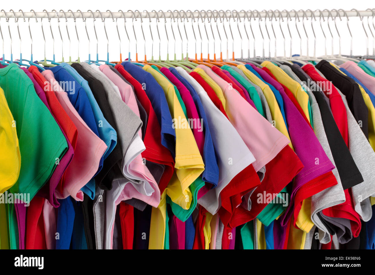 Rack of assorted colored T-shirts. Isolate on white. Stock Photo