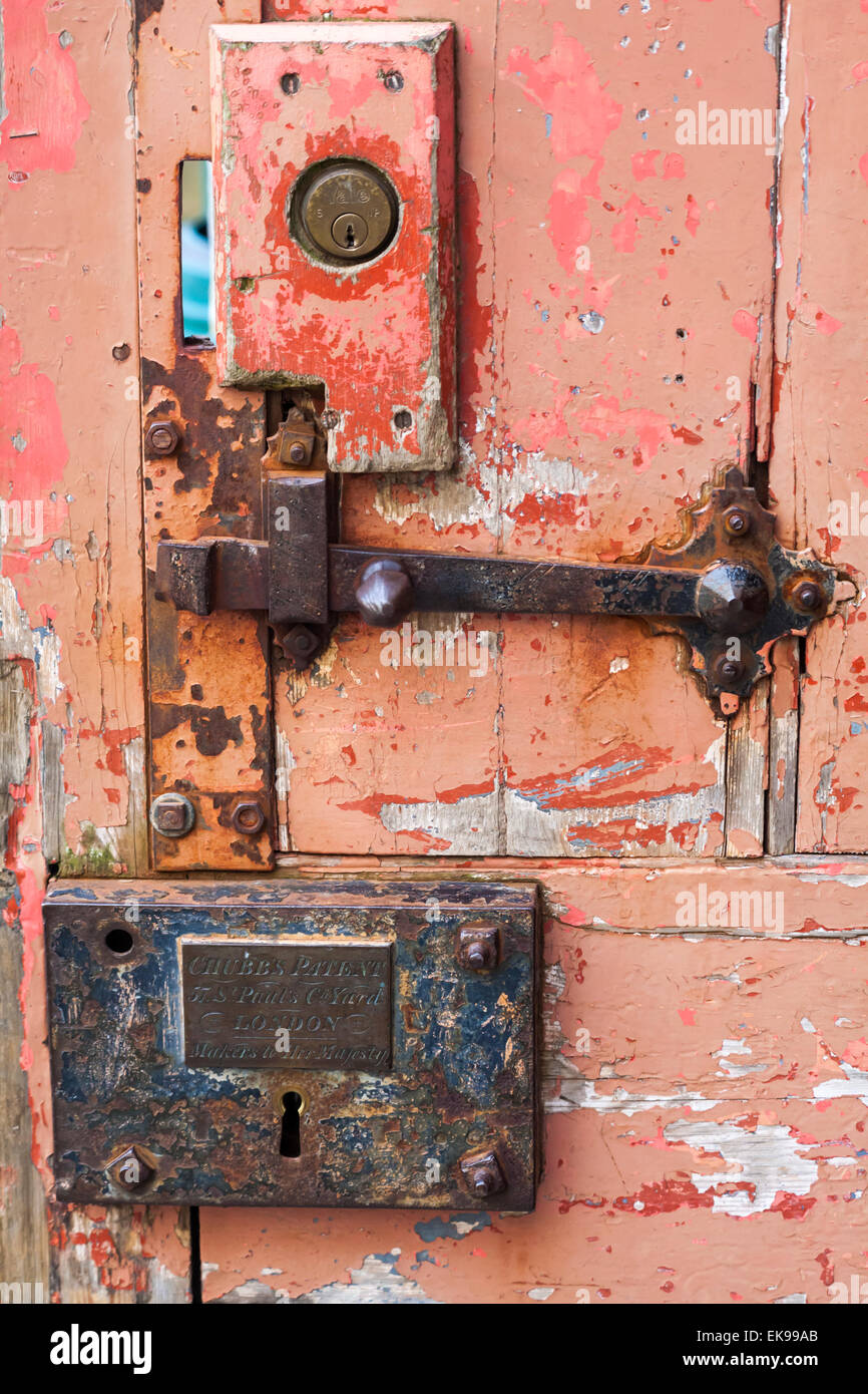 Contrasting modern Yale lock and old Chubb's lock on weathered door in courtyard at Salisbury Cathedral, Salisbury, Wiltshire, UK Stock Photo