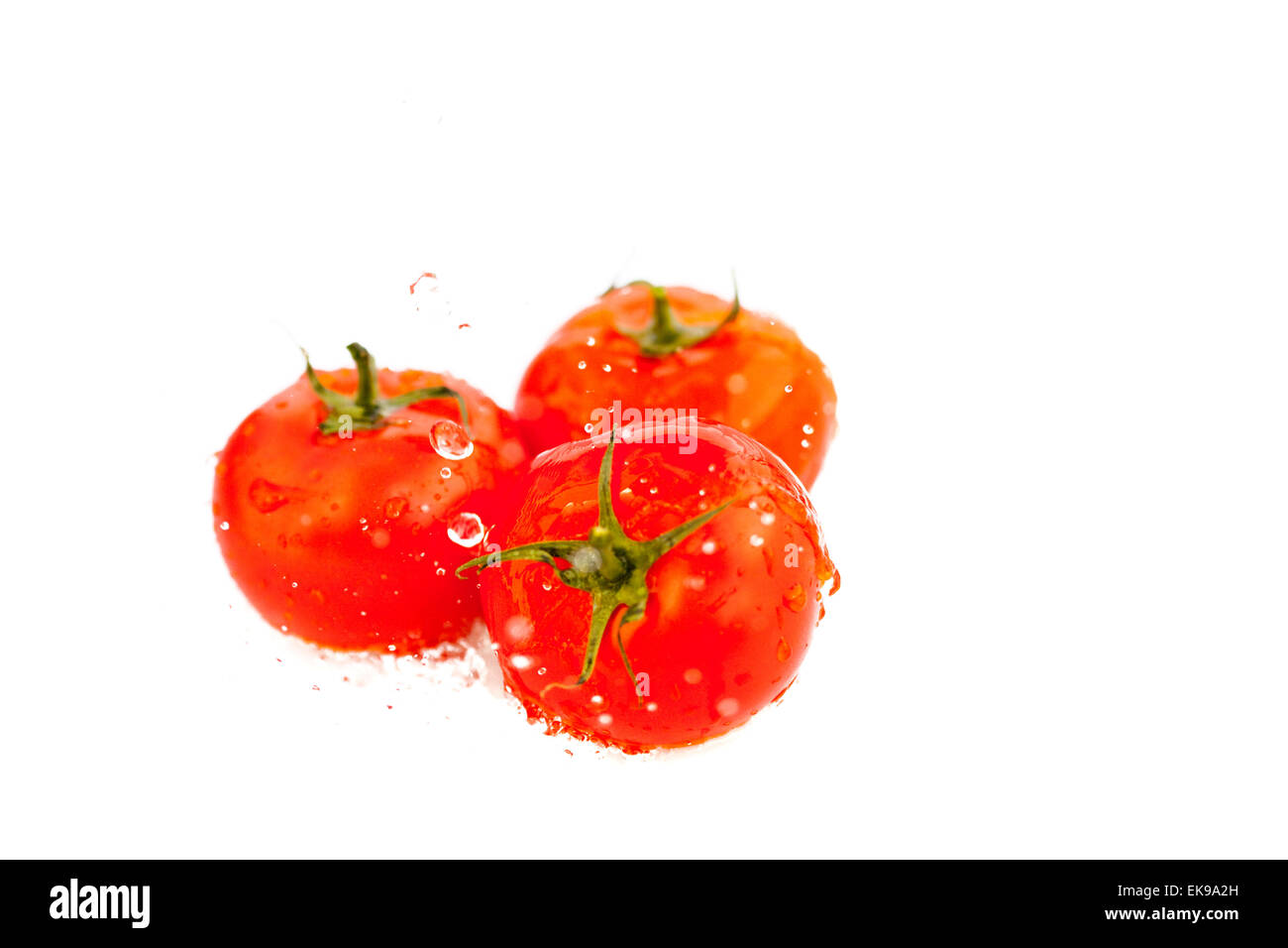 tomatoes with splashes of water isolated on white Stock Photo - Alamy