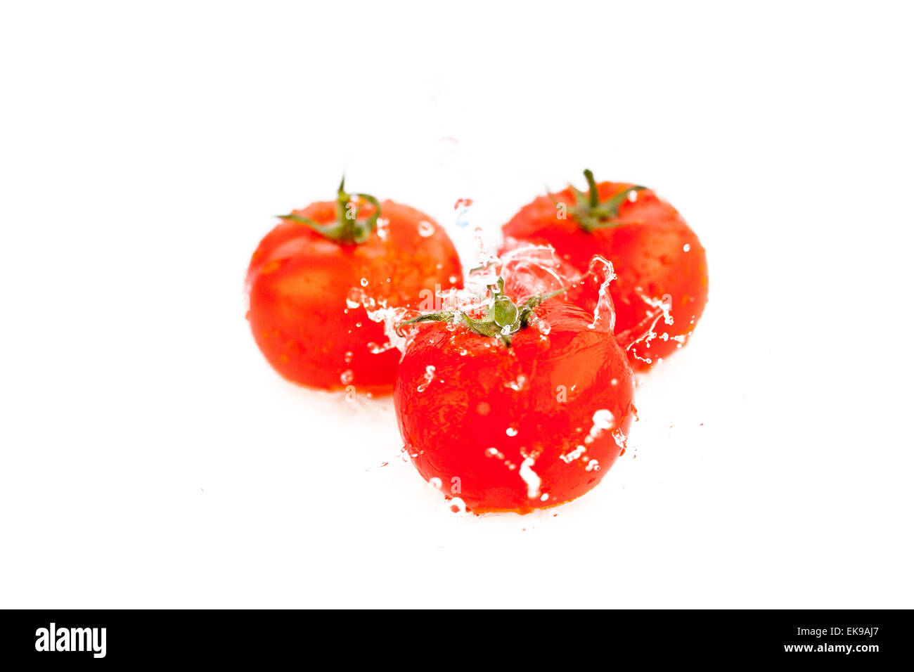 tomatoes with splashes of water isolated on white Stock Photo - Alamy