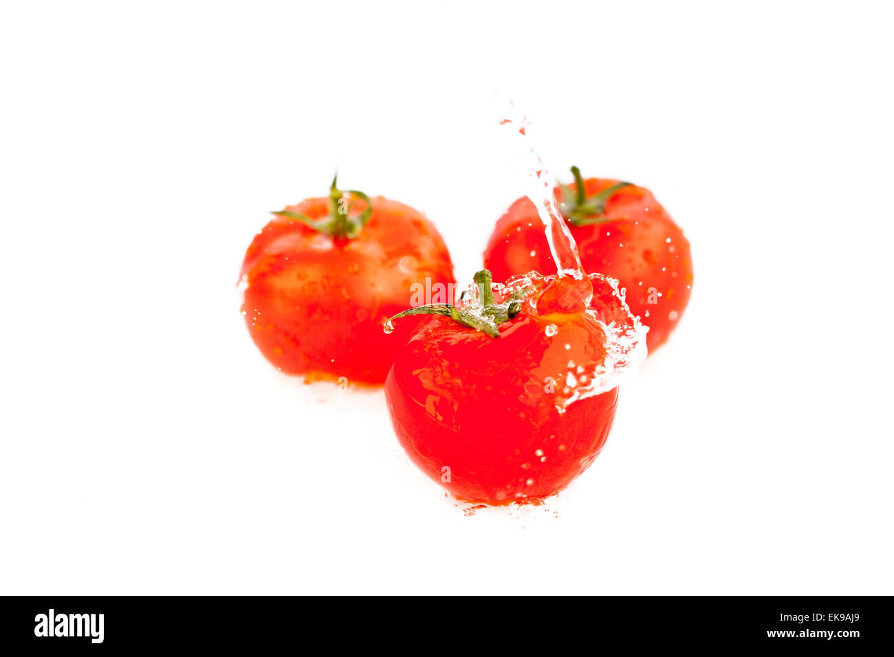 tomatoes with splashes of water isolated on white Stock Photo - Alamy
