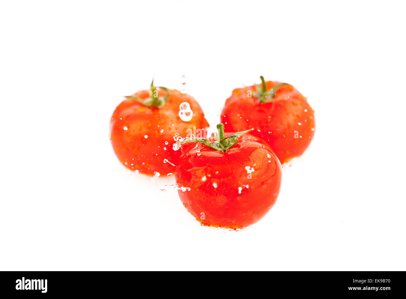 tomatoes with splashes of water isolated on white Stock Photo - Alamy