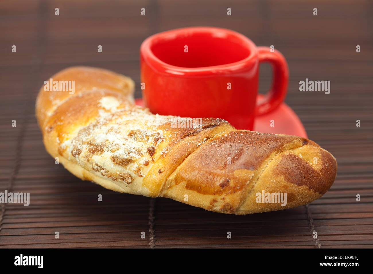 Cup with a plate and roll on a bamboo mat Stock Photo