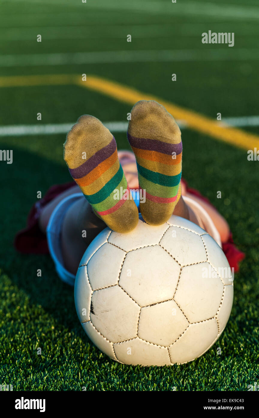 Tired girl with soccer ball after practice. Stock Photo