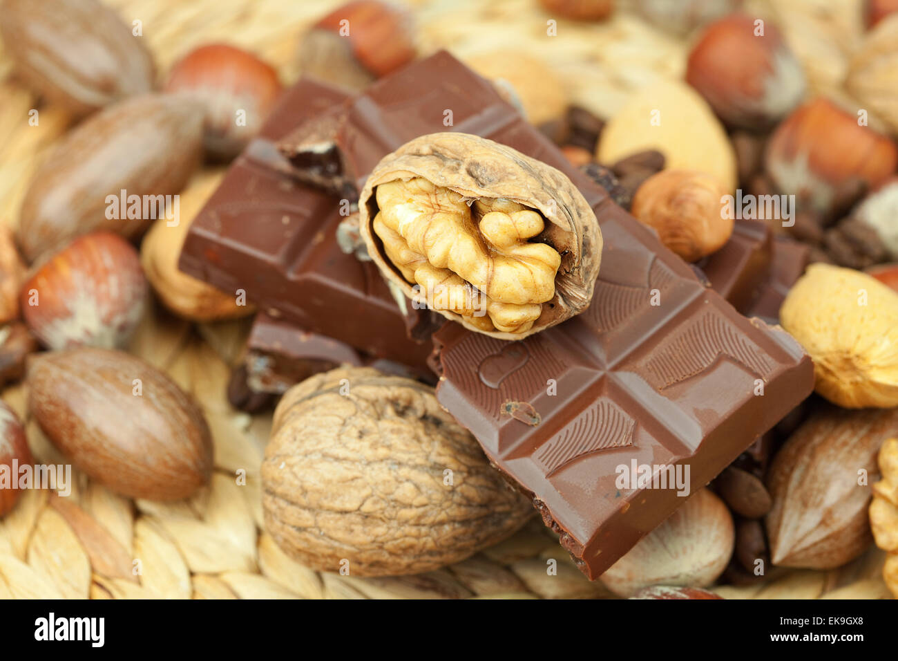 bar of chocolate and nuts on a wicker mat Stock Photo