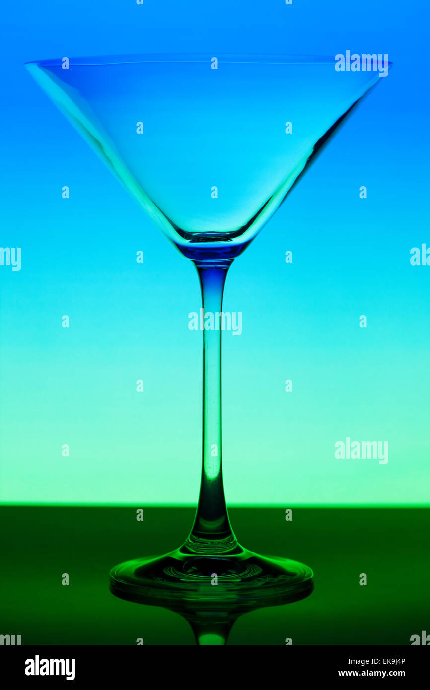 conceptually illuminated martini glass on gradient background Stock