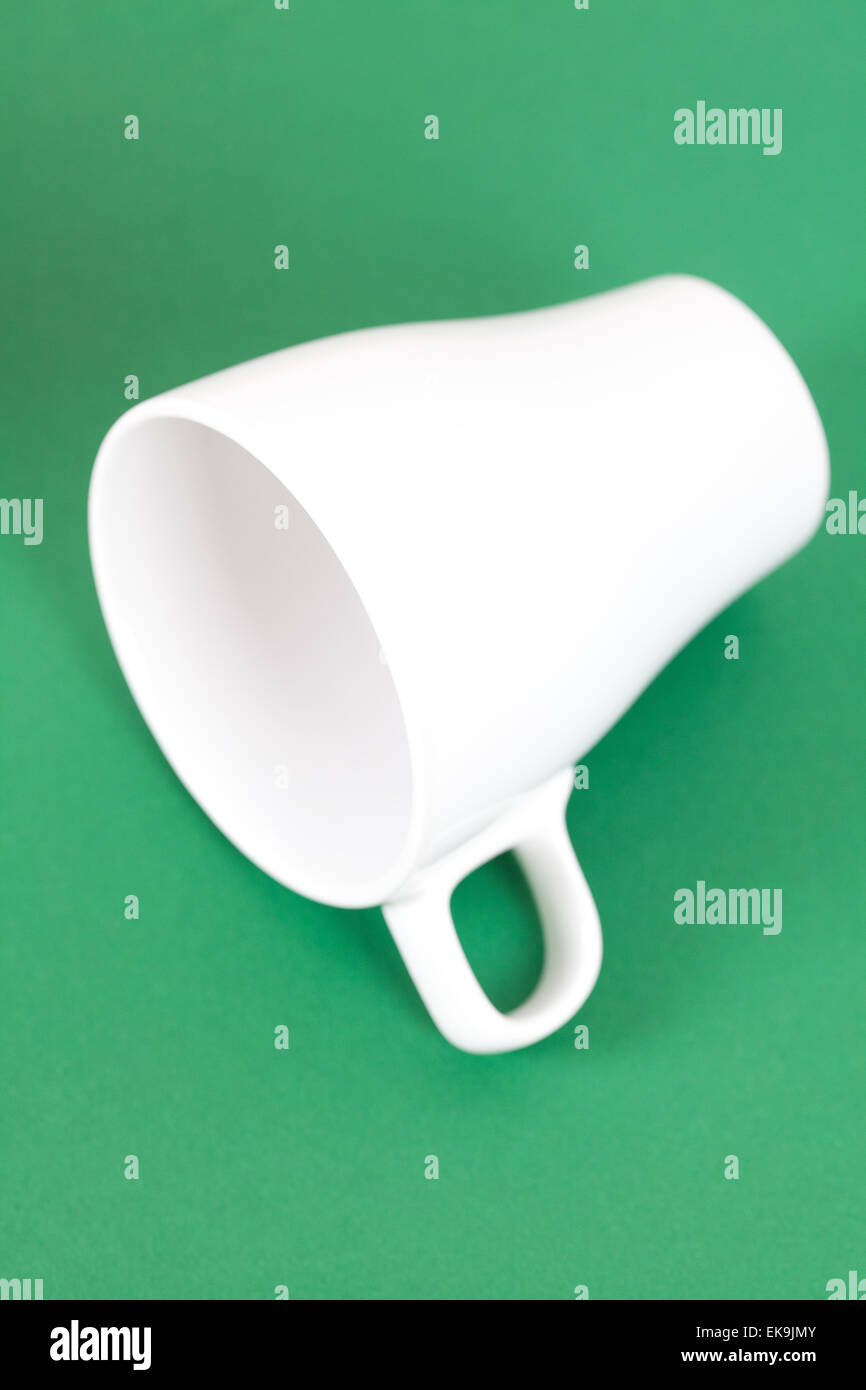 white cup lying on a green background Stock Photo Alamy