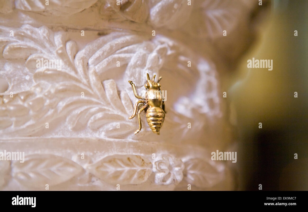 Golden bee detail perched over a marble column, inside the famous church dedicated to our lady at monserrat in Catalonia, Spain Stock Photo