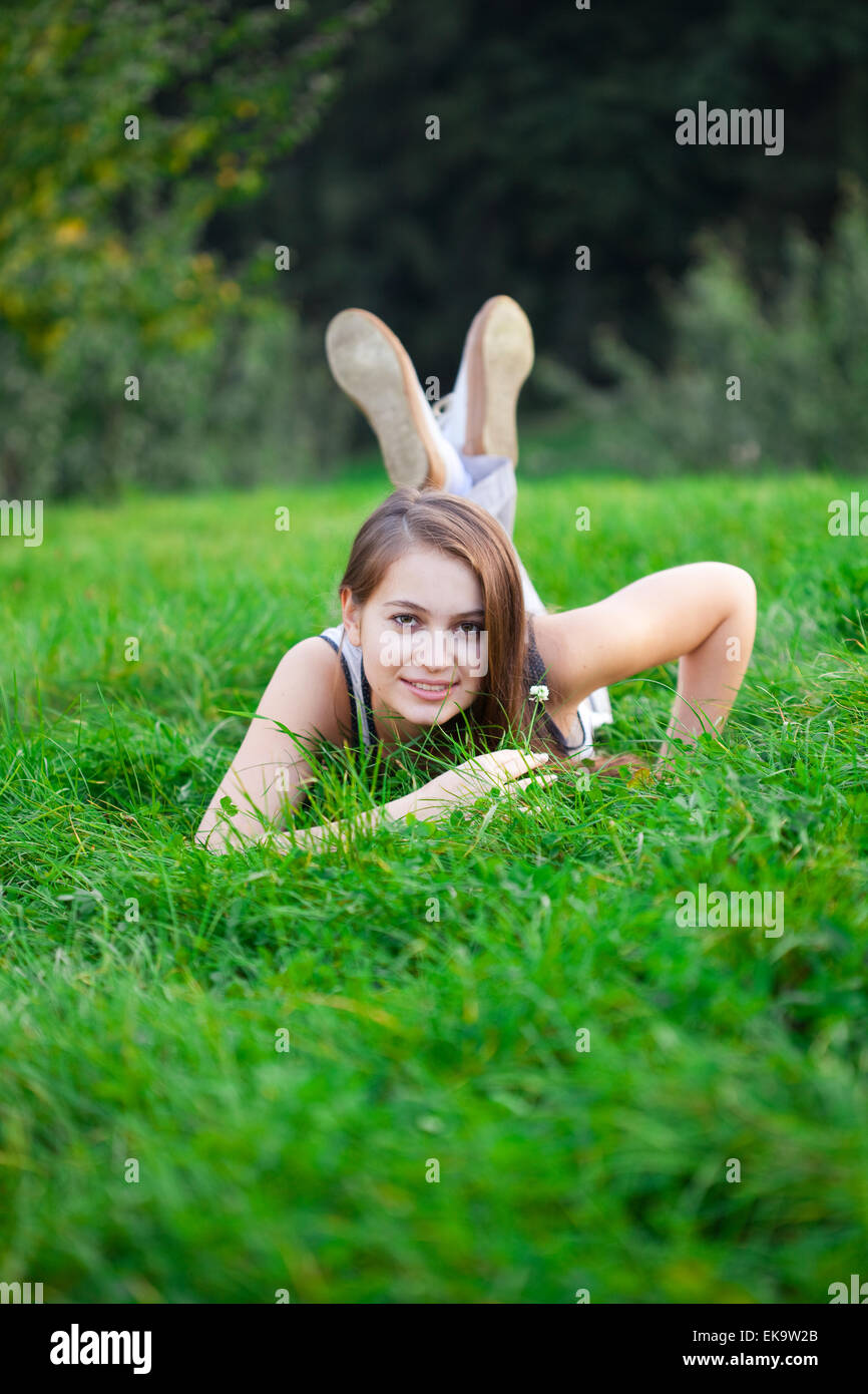 beautiful young woman lying on green grass Stock Photo - Alamy