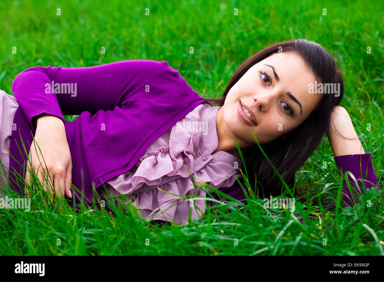beautiful young woman lying on green grass Stock Photo - Alamy