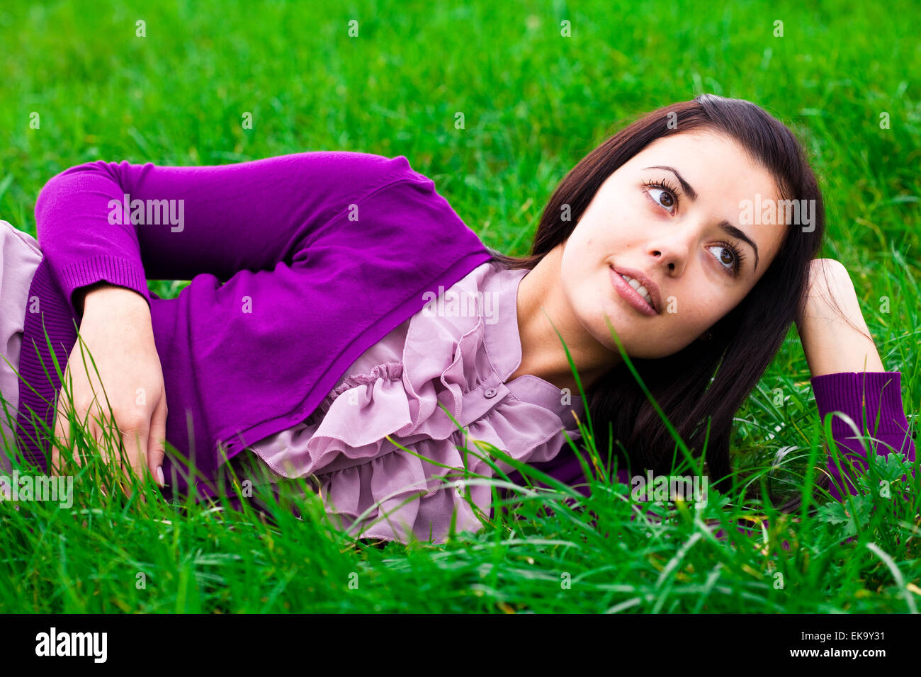 beautiful young woman lying on green grass Stock Photo - Alamy