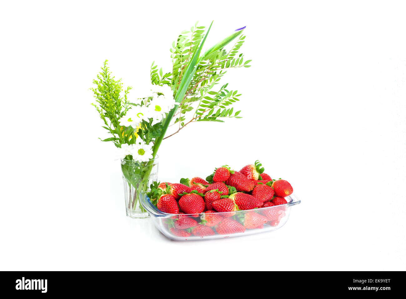 big juicy red ripe strawberries in a glass bowl and flower isola Stock ...