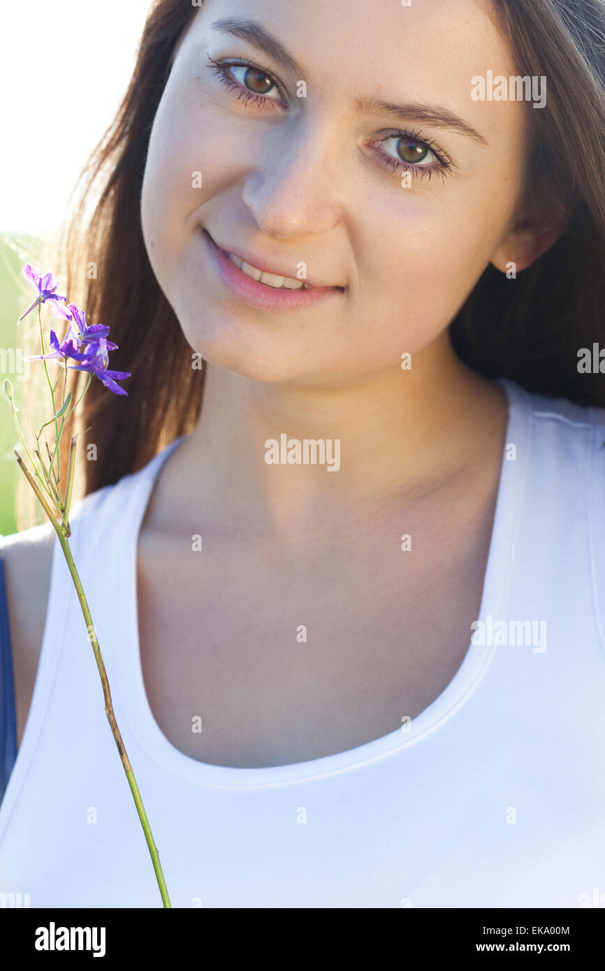 portrait of a beautiful young woman with flower outdoor Stock Photo - Alamy