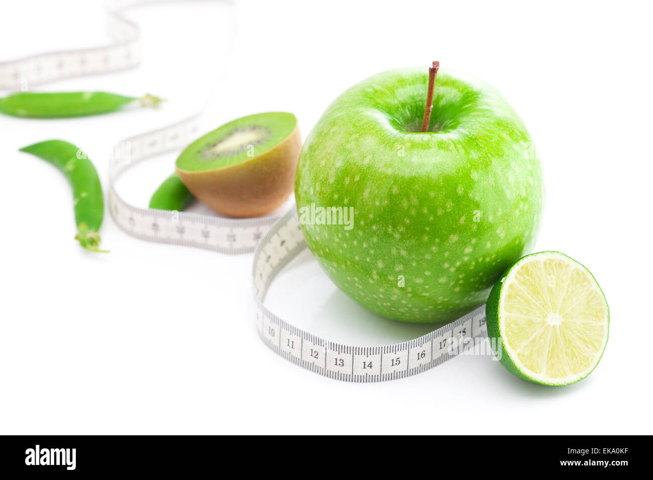 apple lime peas kiwi and measure tape isolated on white Stock