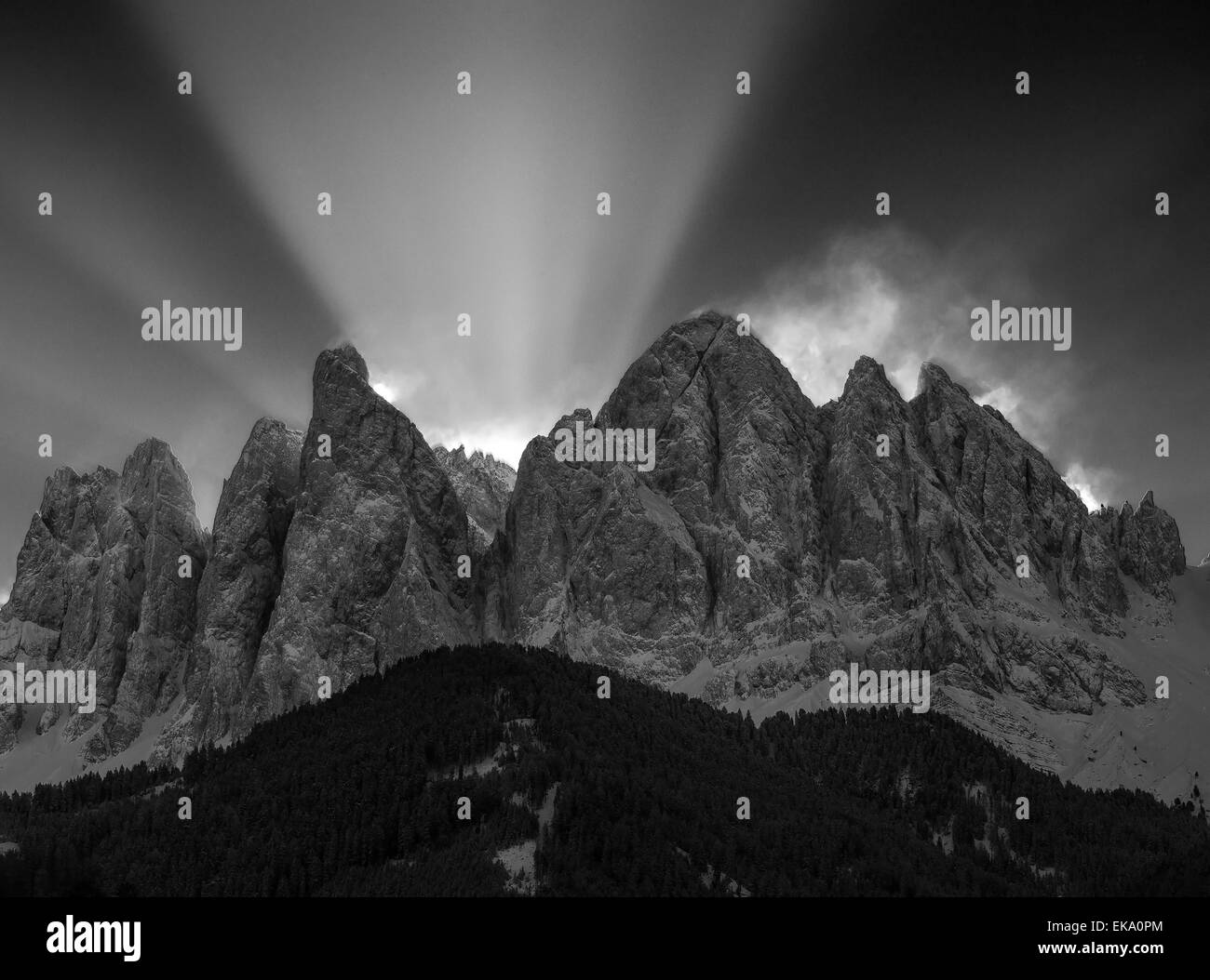 Beams of light in winter, the Odle mountain group. Sass Rigais and Furchetta peaks. The Dolomites of Funes vaalley. Black white landscape. Italy. Stock Photo