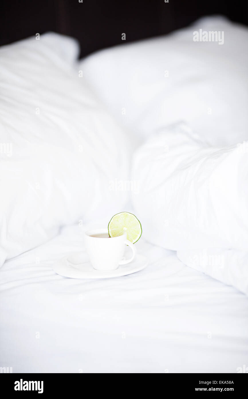 bed with a pillow and a cup of tea Stock Photo