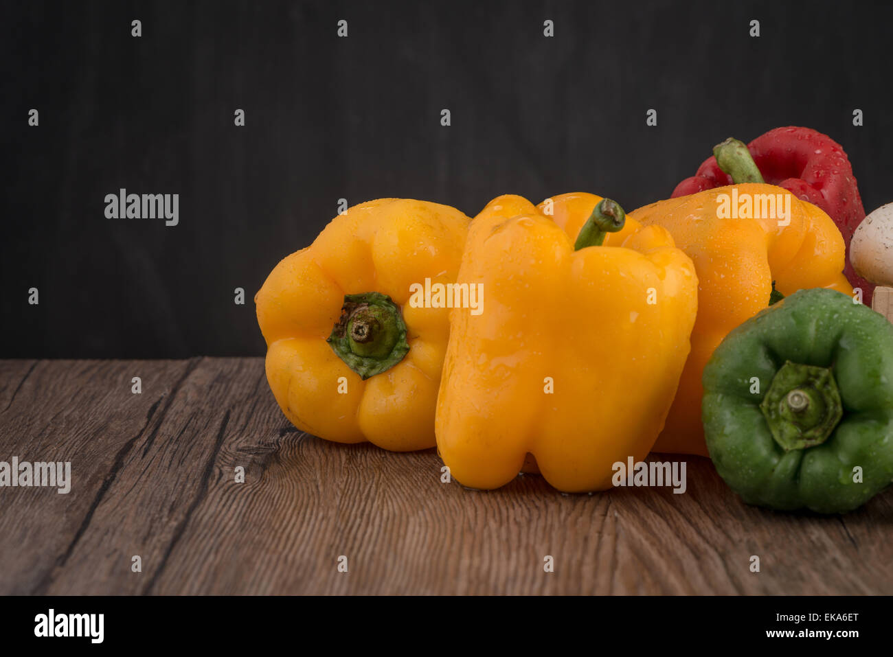 Colored bell peppers on old wooden table Stock Photo - Alamy