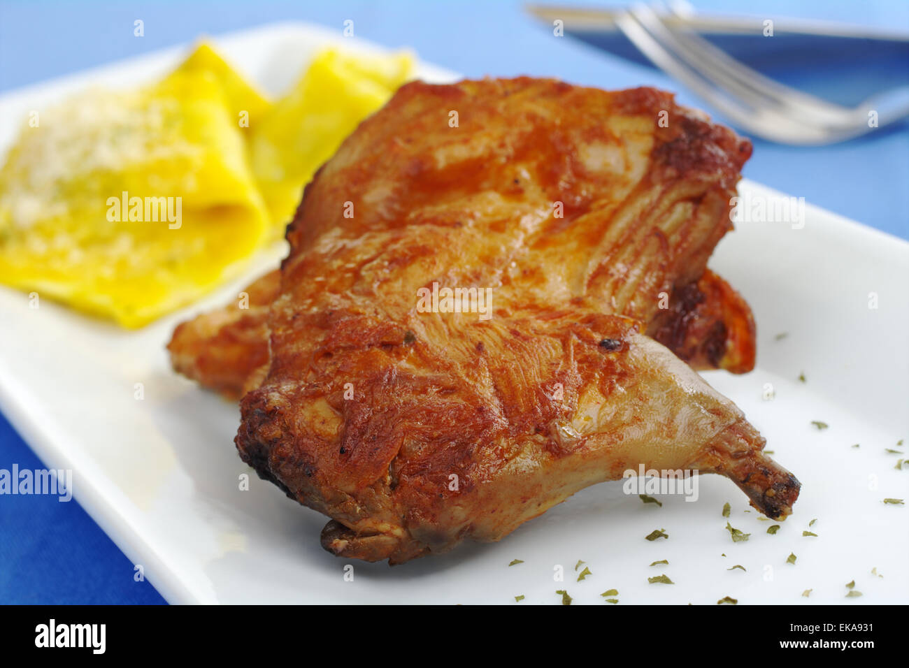 Main Dish Guinea pig meat with ravioli on white rectangular plate