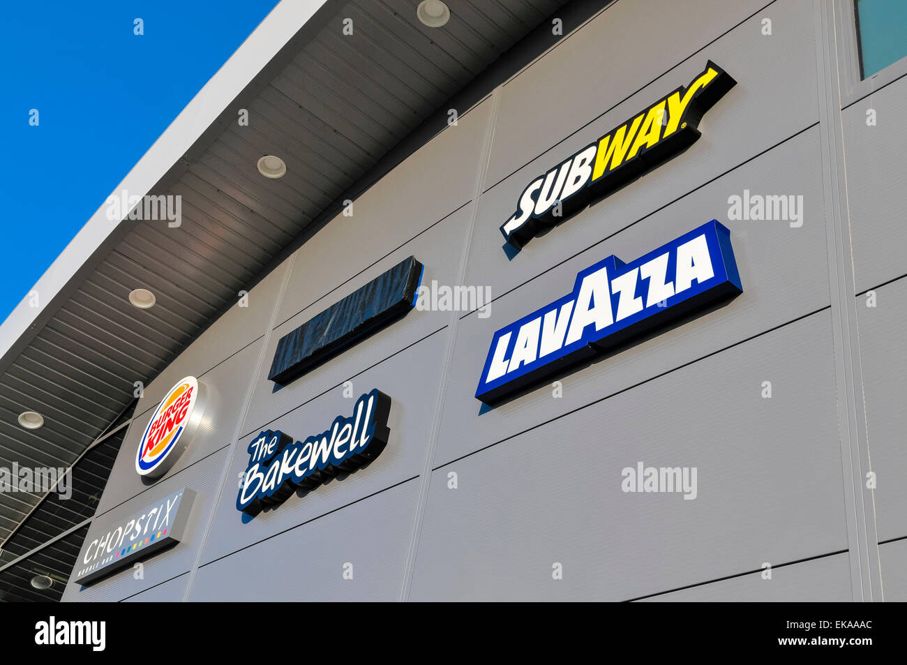Signs for brands on sale inside a motorway service station Stock Photo