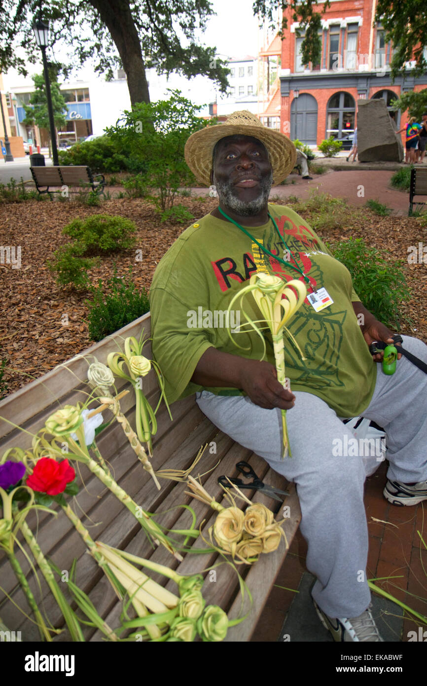 African american man selling river street roses weaved from palm fronds in Savannah, Georgia, USA. Stock Photo